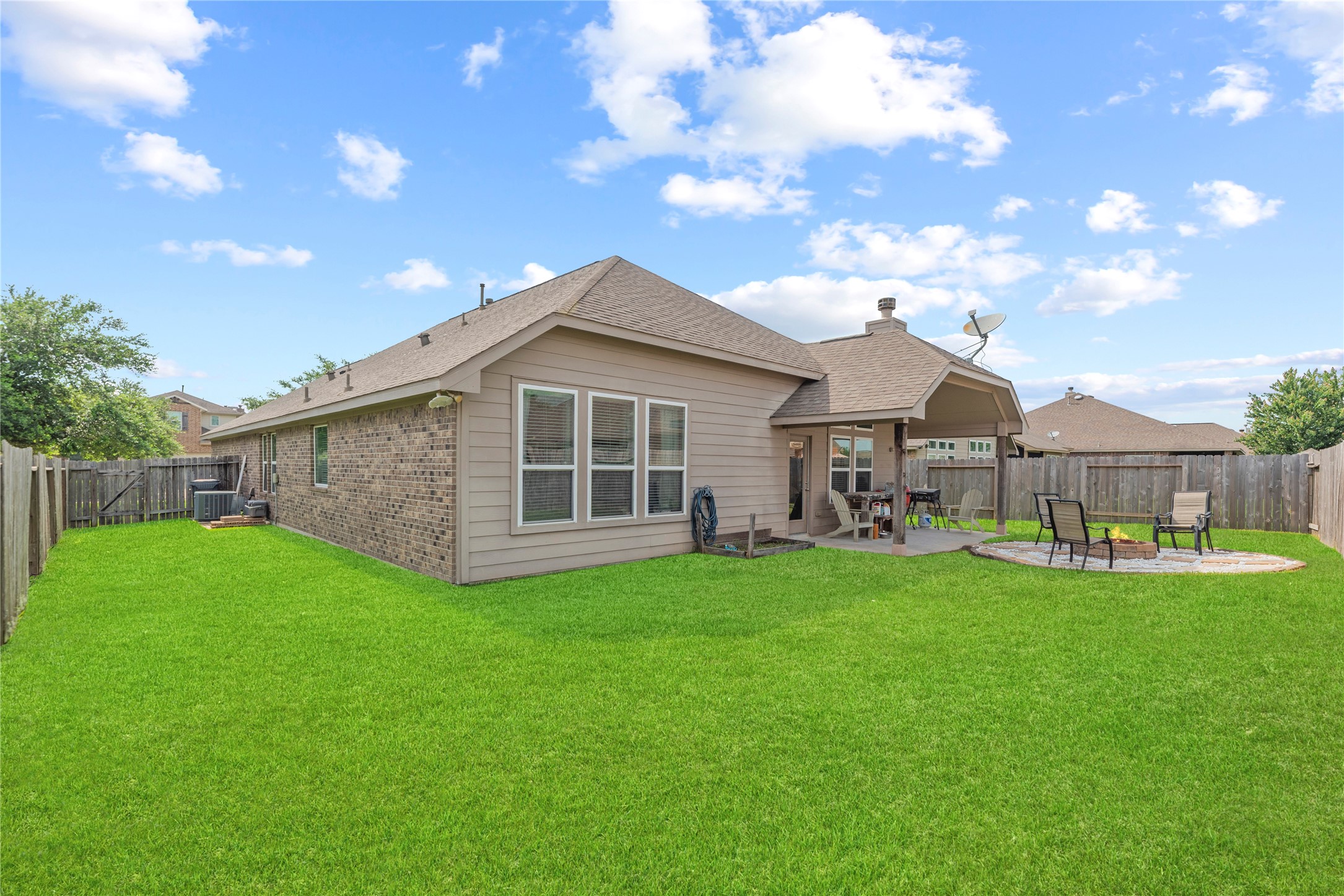Private backyard with a covered patio and fire pit area.