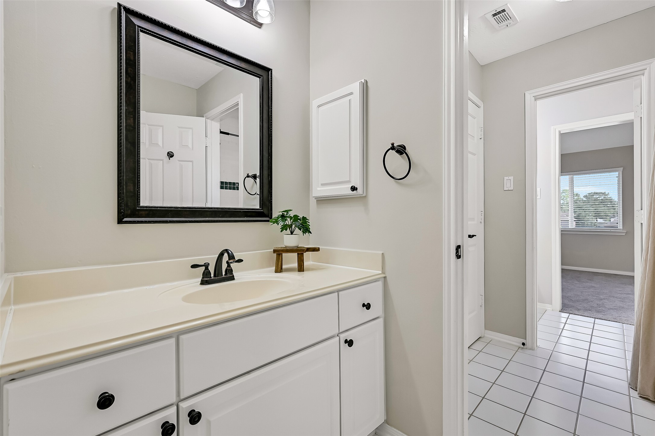 On the opposite side of the Jack & Jill bath, a second private vanity provides another generous countertop, sink & storage area. The thoughtful layout gives each adjoining bedroom its own dedicated prep space while sharing the central tub/shower and toilet.