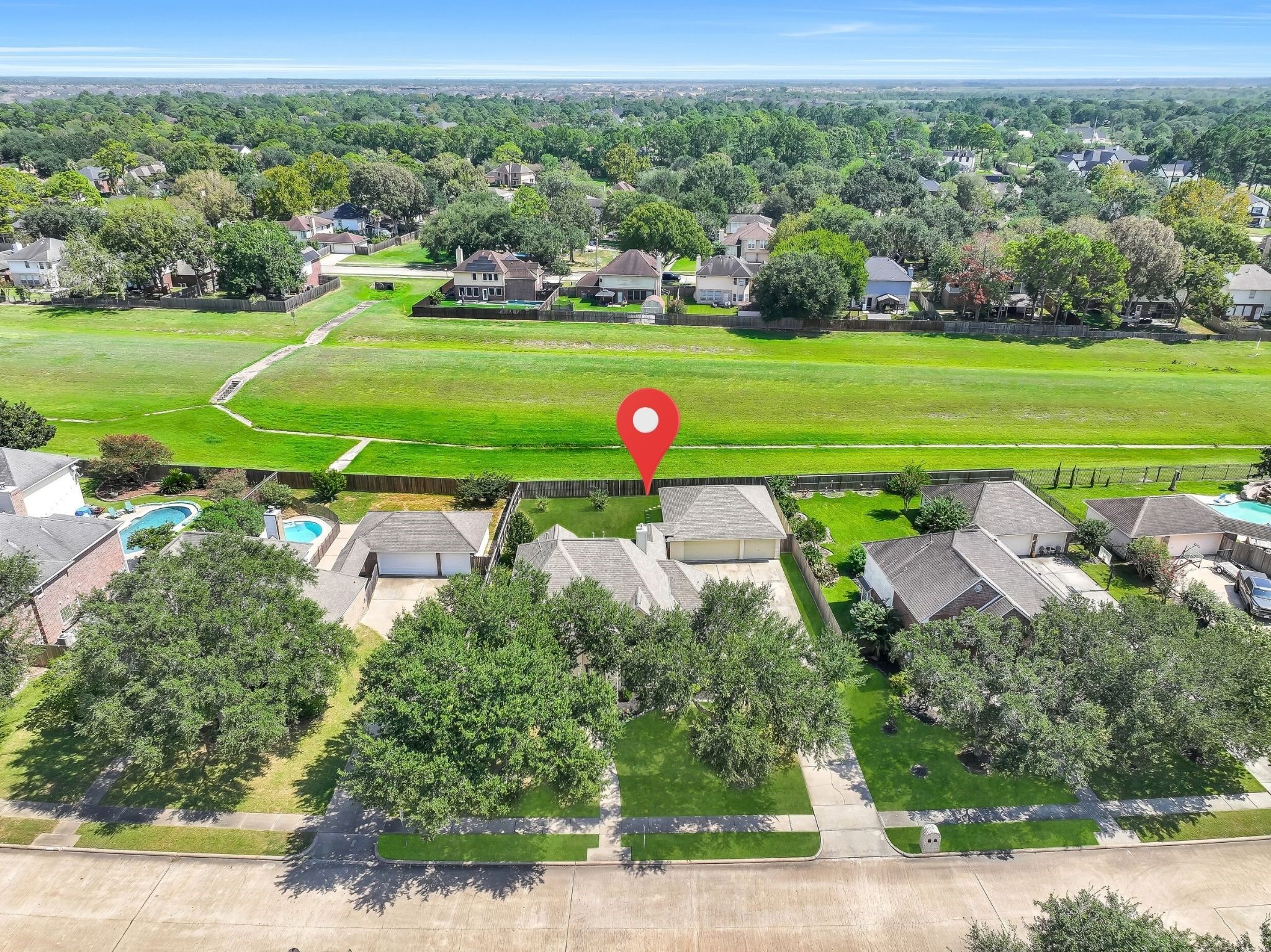 This aerial perspective captures the homes generous homesite, detached 3-car garage and expansive pool-sized backyard. Open space directly behind the property creates additional separation from neighboring homes and enhances the backyards sense of privacy.