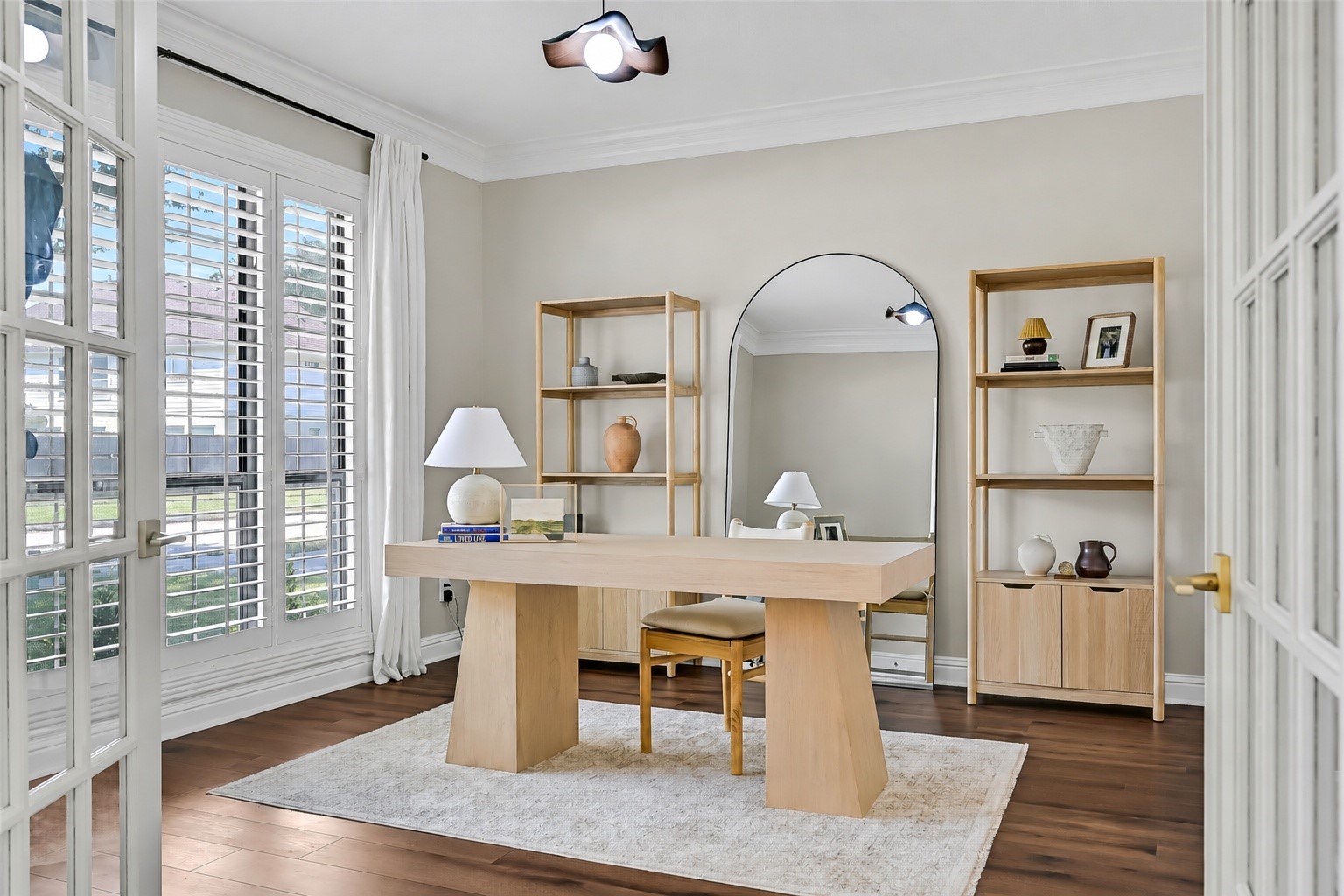 French doors open to a private study with abundant natural light, plantation shutters, crown molding & luxury vinyl plank flooring. Generous dimensions easily accommodate a substantial desk and additional furnishings for a comfortable work-from-home space.
