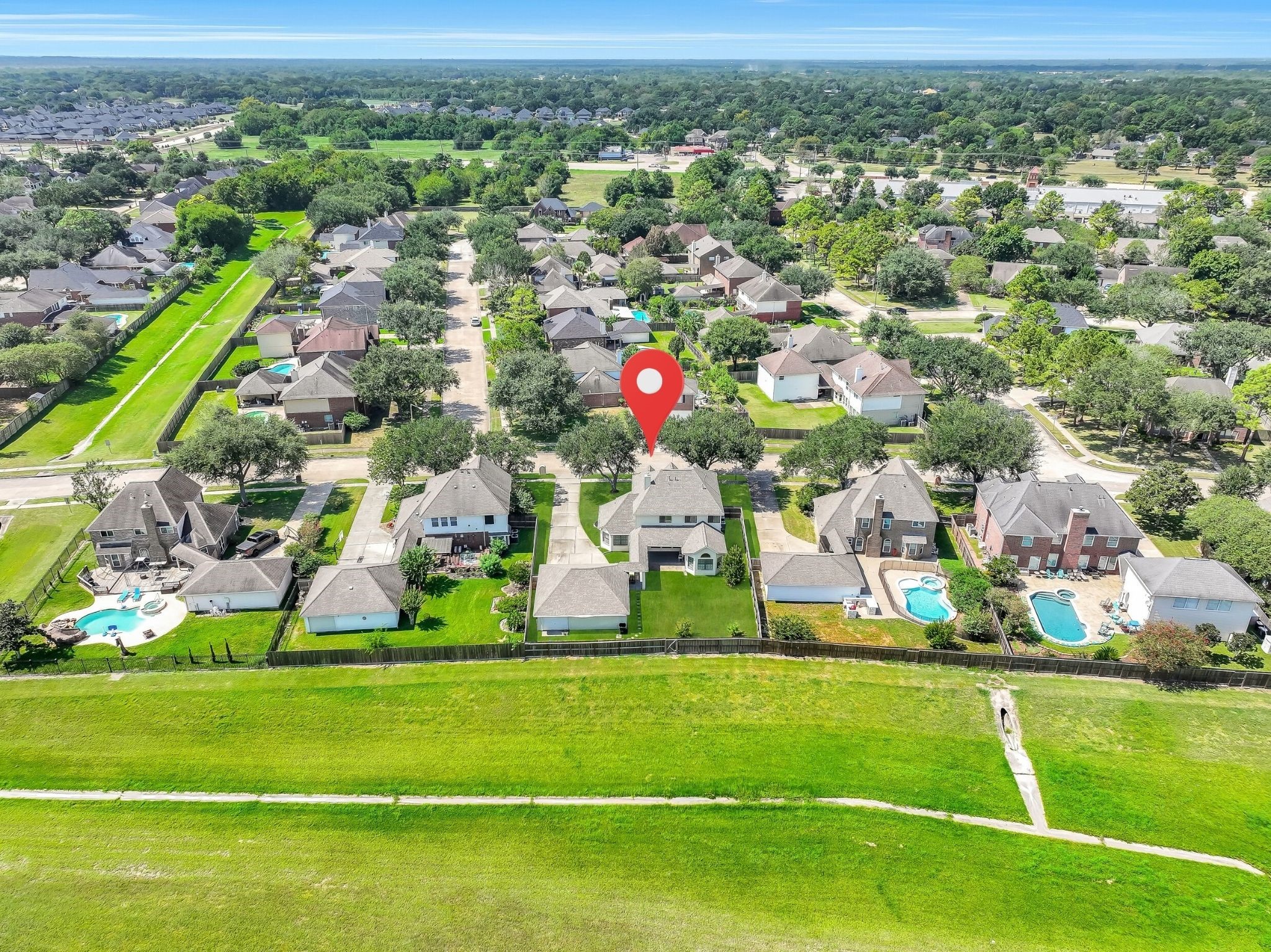An elevated neighborhood view highlights the propertys location within established Boca Raton. The home enjoys a spacious lot with mature trees, a large backyard and no immediate rear neighbors, all within highly regarded Friendswood ISD.