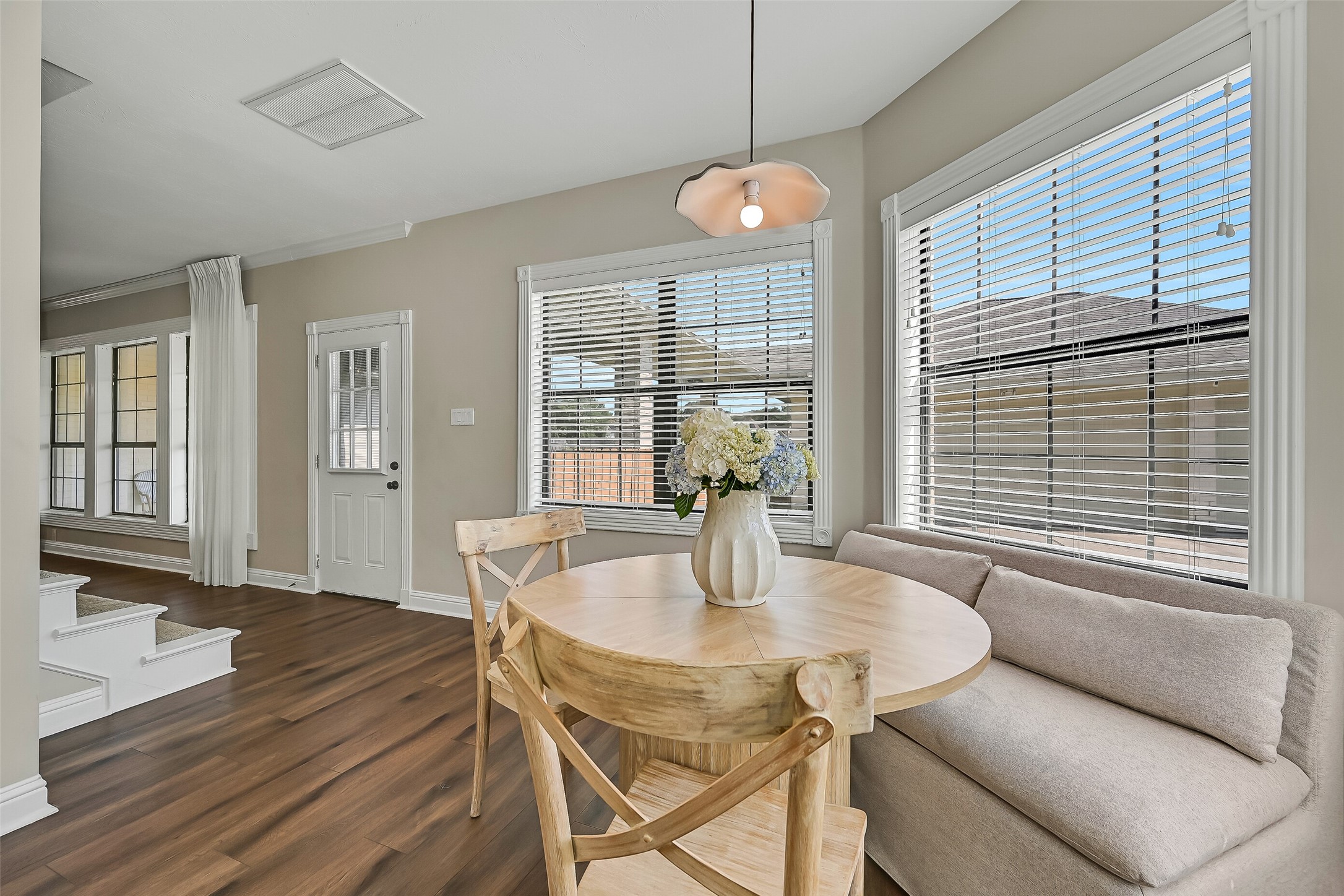 From the family room, the floor plan flows naturally into the sunny breakfast area and kitchen. Luxury vinyl plank flooring unifies the spaces, while numerous windows bring in natural light and provide views across the large fenced backyard.