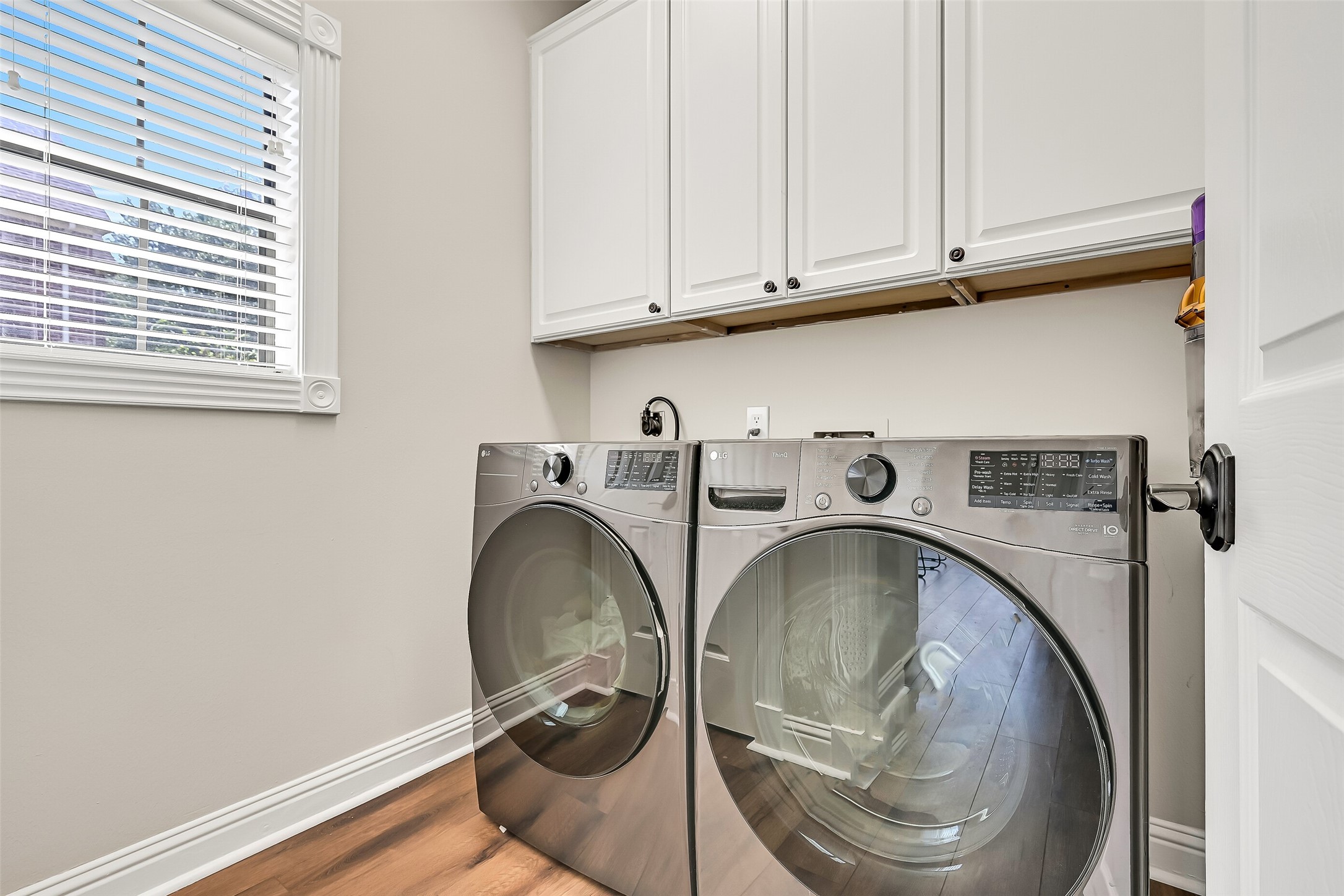 The dedicated utility room offers upper cabinetry for convenient storage, space for full-size appliances and a window for natural light. Its separate location keeps laundry neatly tucked away from the homes primary living and entertaining spaces.