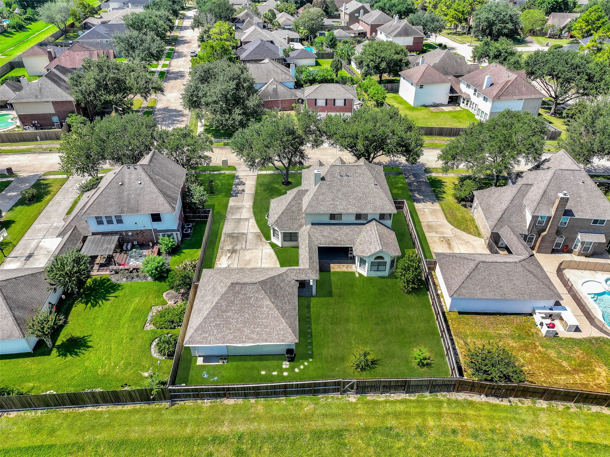 A wide backyard view showcases just how much usable outdoor space this property offers. The large fenced lawn is complemented by a substantial covered patio, detached 3-car garage and the added privacy of having no immediate rear neighbors.
