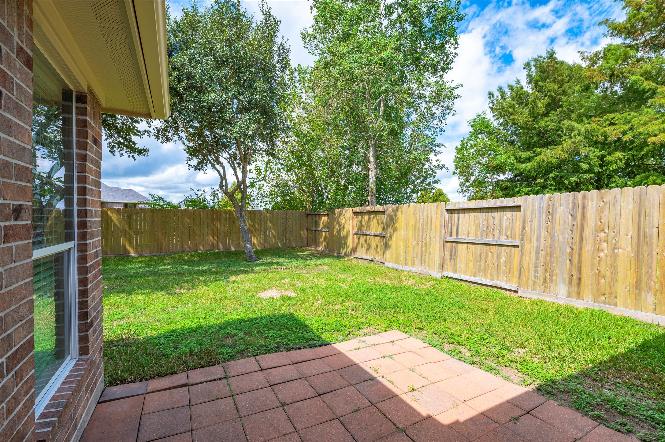 Brick back patio area and large backyard.