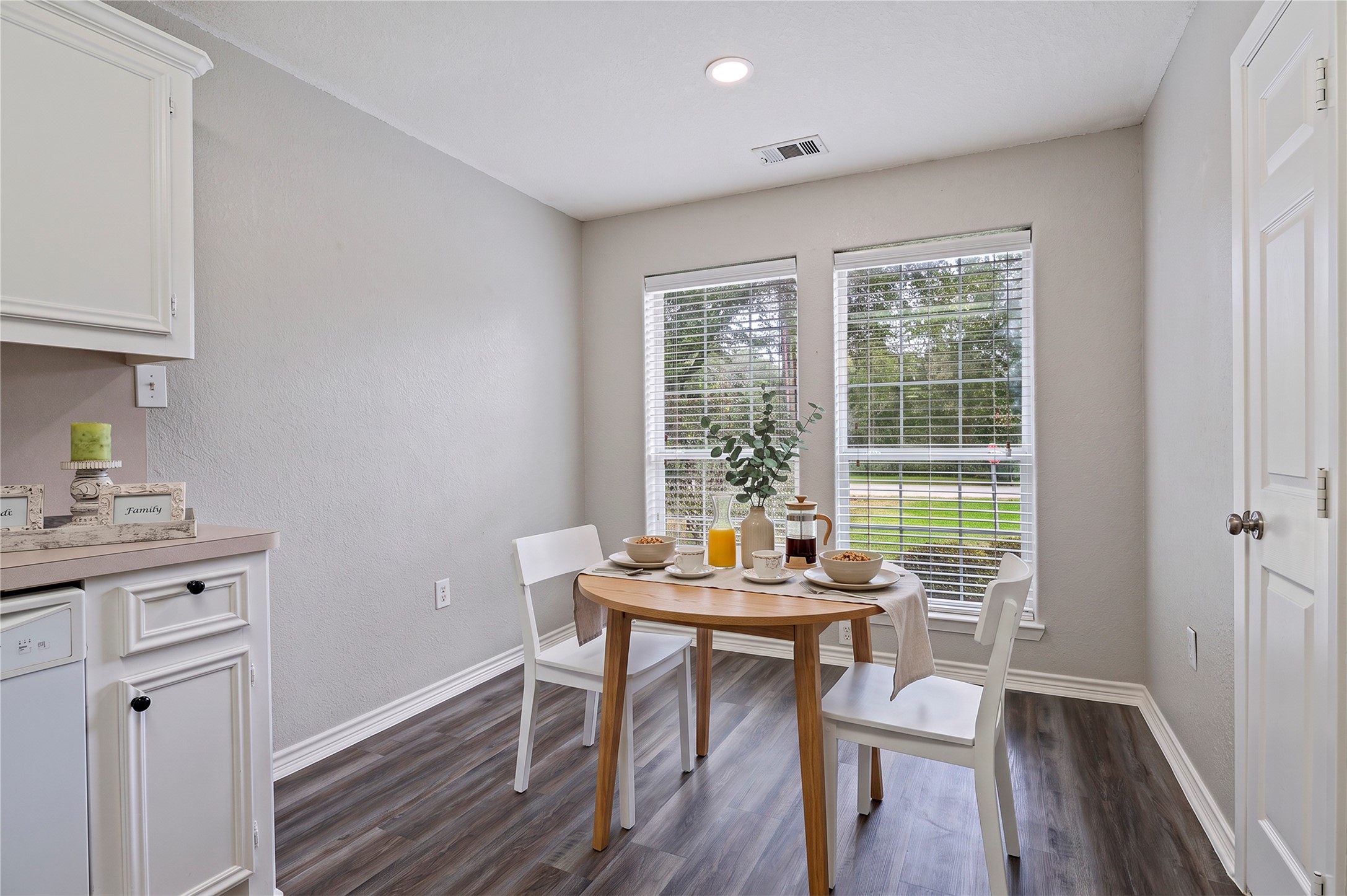 Virtually staged breakfast area with views of the front yard.