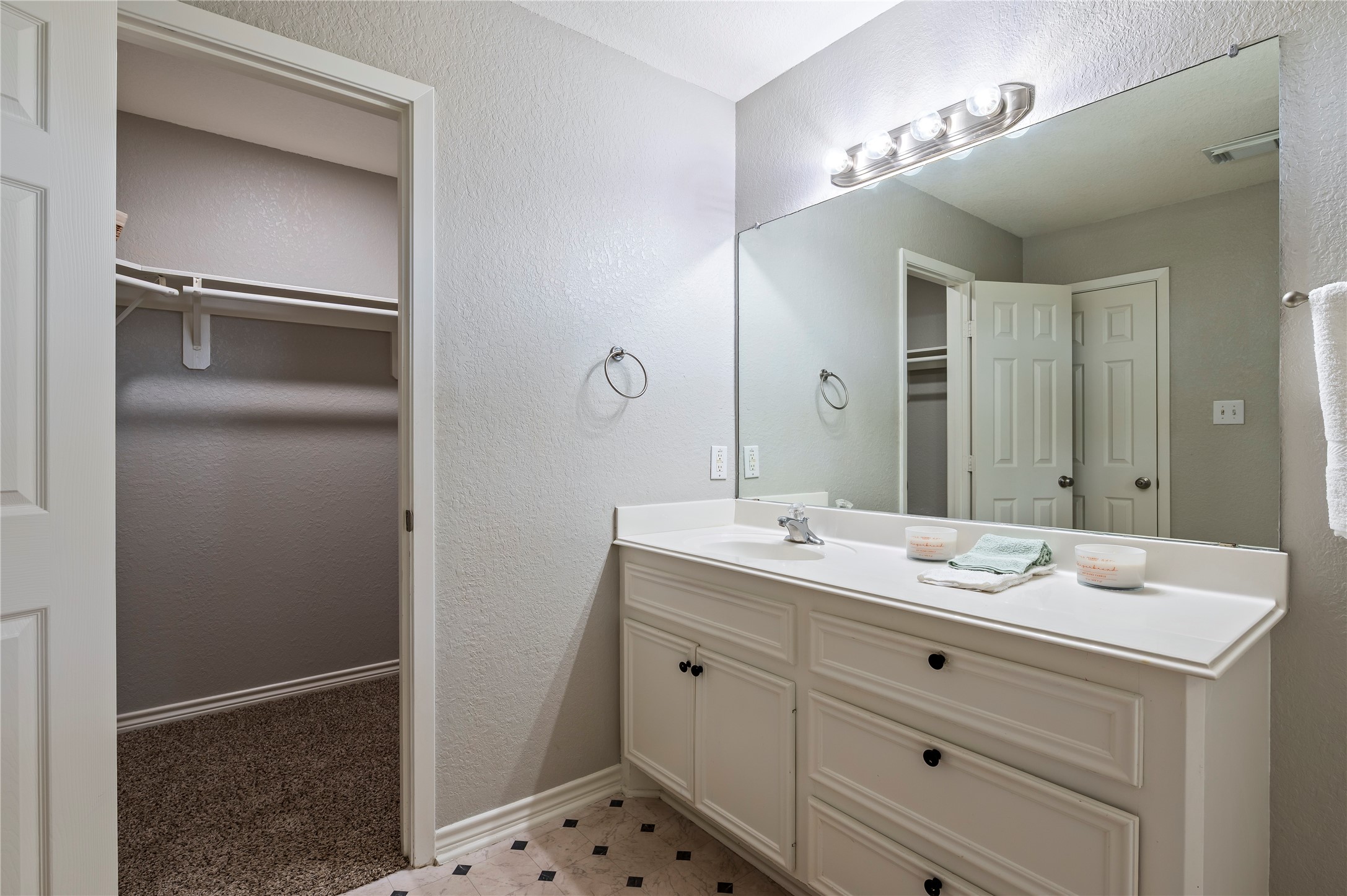 Another view of the primary bath vanity and walk in closet.