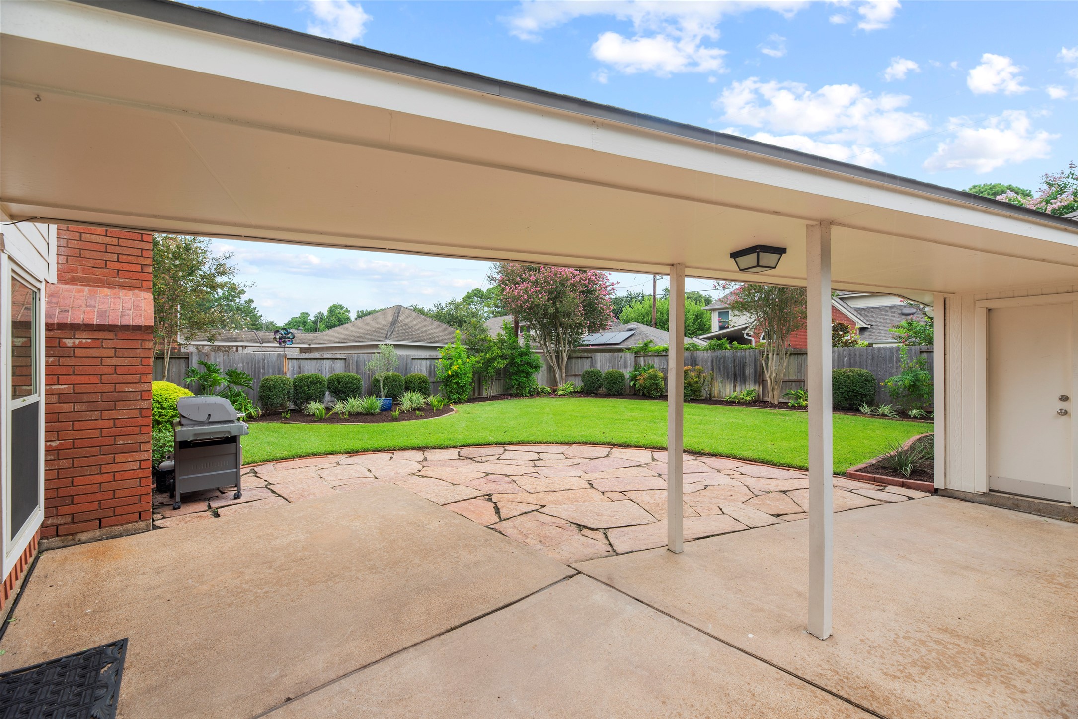 A covered breezeway connects the home & detached garage, opening to an expansive flagstone patio & beautifully landscaped backyard with a full sprinkler system, ready for outdoor dining, entertaining & relaxing.