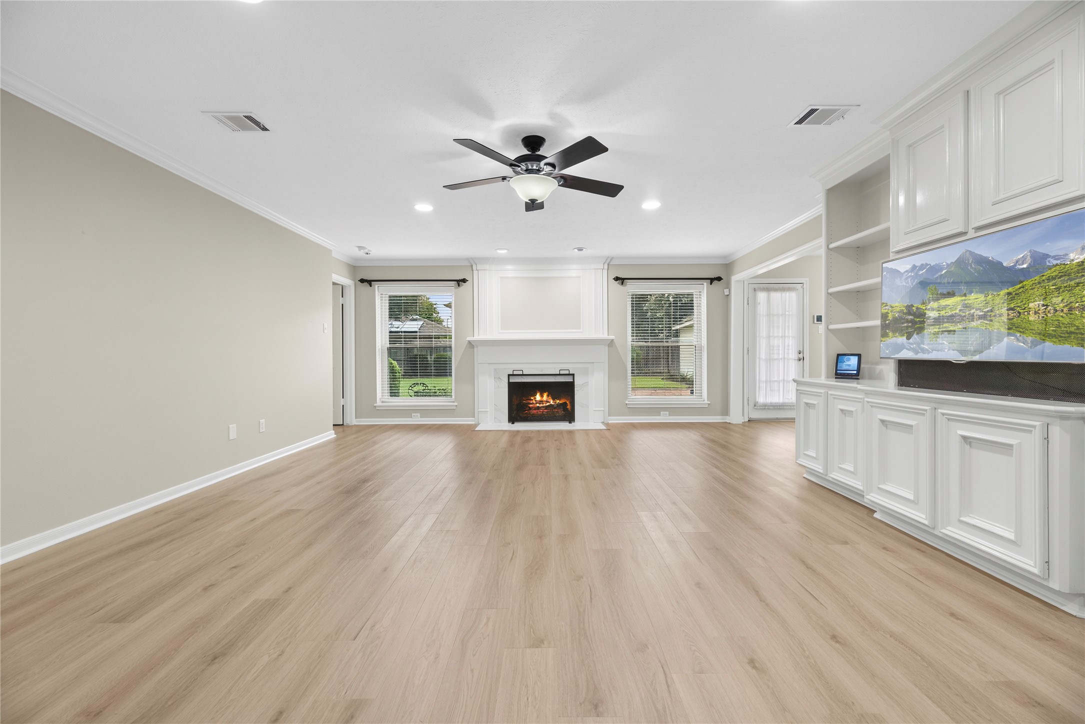 Competing for equal attention, the gas-log fireplace with its elegant porcelain surround offers the perfect spot for a favorite portrait, while the wall of custom built-ins is ready to showcase treasured collectibles and special keepsakes. Competing for equal attention, the gas-log fireplace with its elegant porcelain surround offers the perfect spot for a favorite portrait, while the wall of custom built-ins is ready to showcase treasured collectibles and special keepsakes.