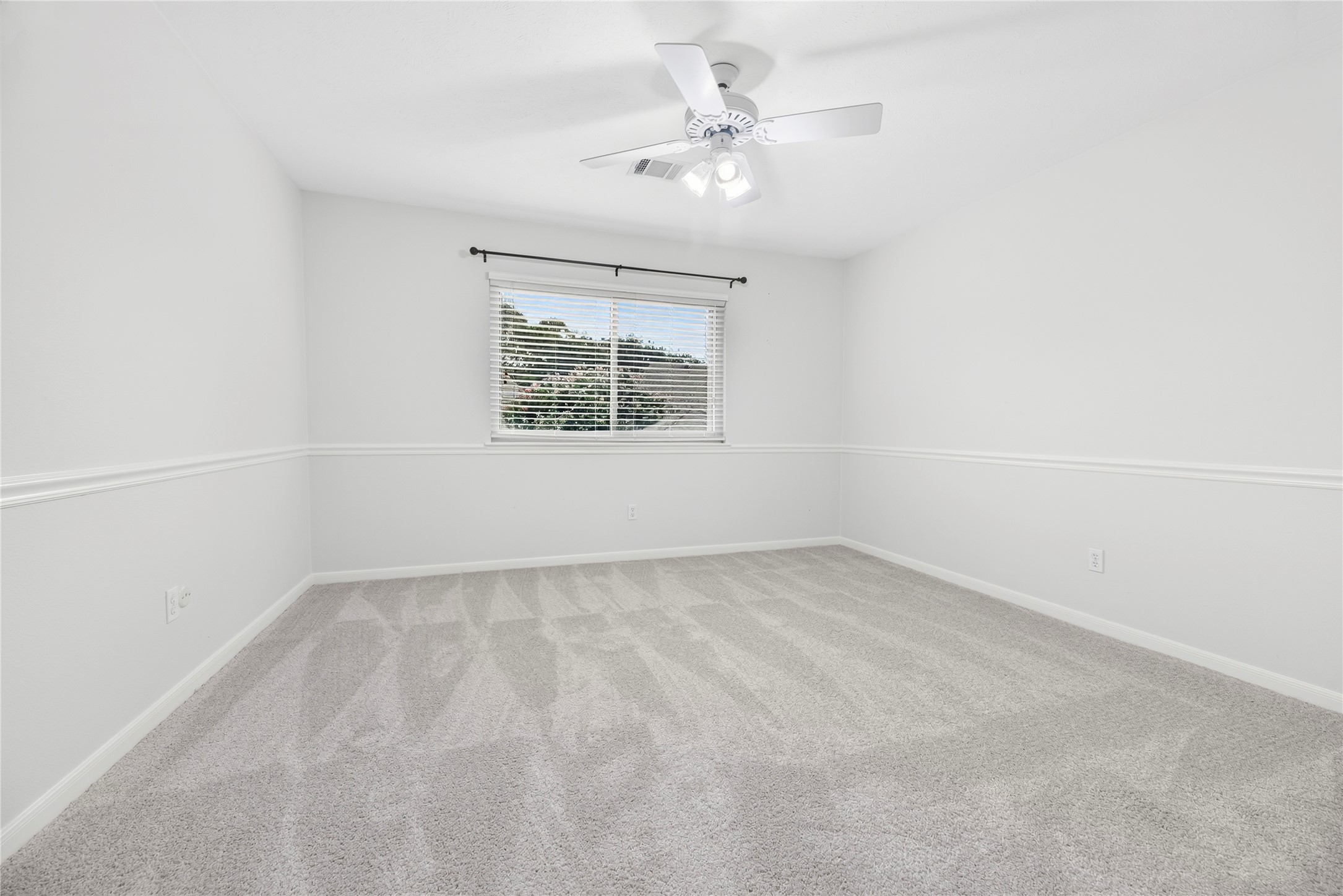 Your family and guests will rest comfortably in any of the three upstairs bedrooms. This roomy bedroom offers a large walk-in closet, updated carpet installed in July 2026, fresh paint, a ceiling fan and large windows that fill the space with natural light and peaceful treetop views.