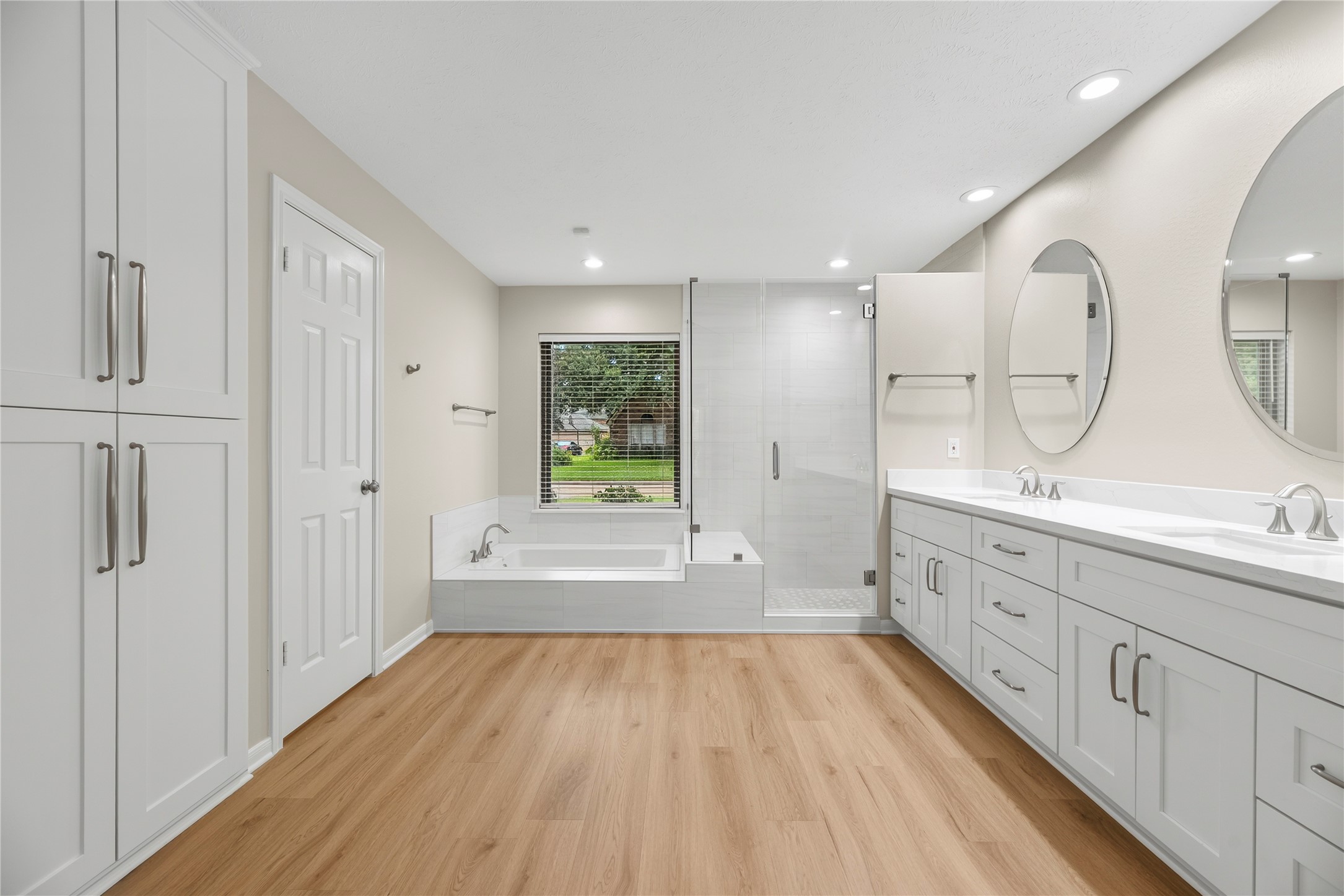 Updated in October 2025, this polished ensuite pairs crisp finishes, extensive storage, updated LVP flooring & an updated window w/a deep soaking tub & sleek glass-enclosed shower w/body sprays, giving you the perfect choice between a long, lazy soak or a relaxing rinse.