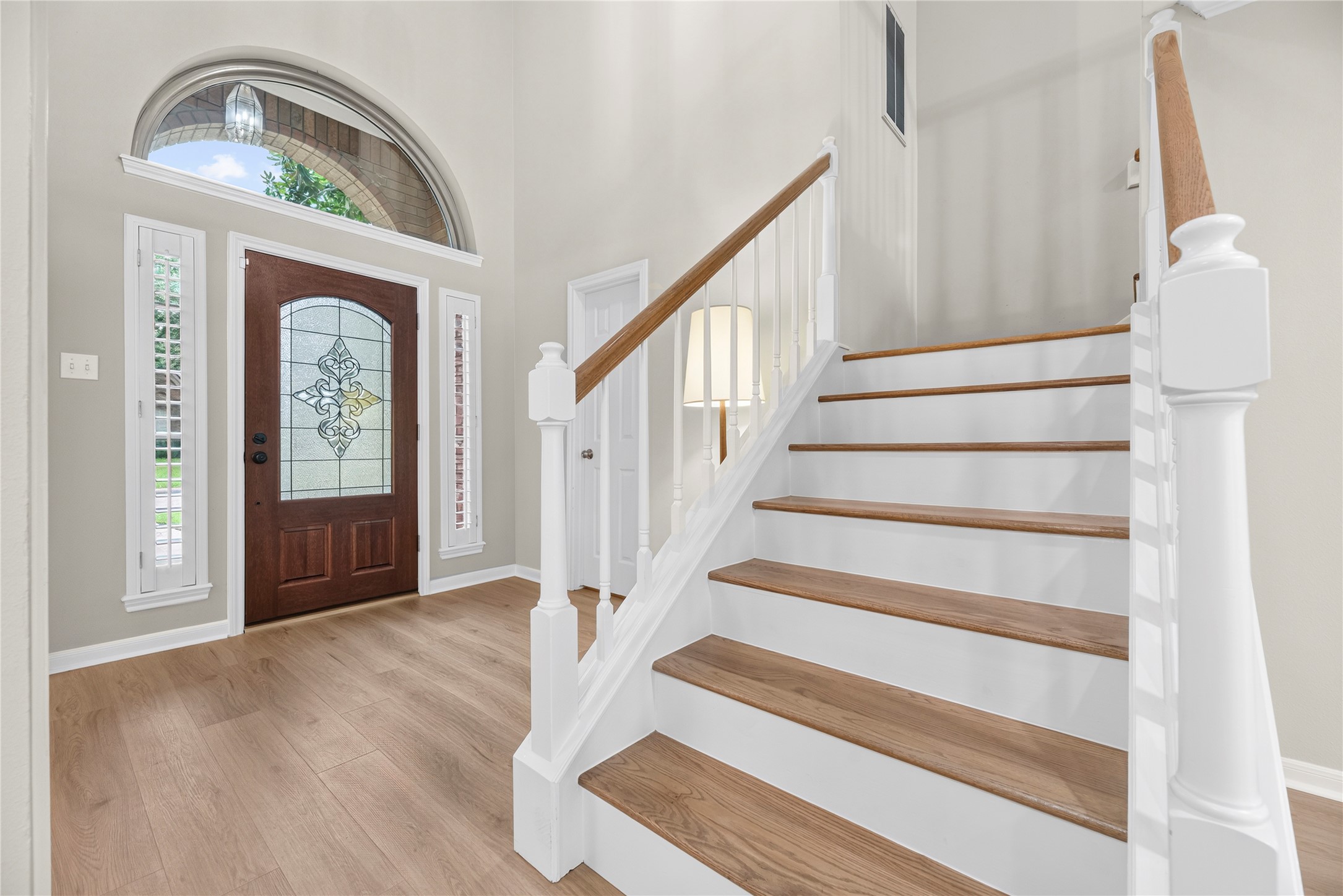 A stunning leaded glass front door, shuttered sidelights & an impressive palladium window above fill the foyer with natural light, while the oak hardwood staircase adds warmth & timeless character. It is a welcoming introduction to the comfortable, light-filled spaces found from the front door to the back. A stunning leaded glass front door, shuttered sidelights & an impressive palladium window above fill the foyer with natural light, while the oak hardwood staircase adds warmth & timeless character. It is a welcoming introduction to the comfortable, light-filled spaces found from the front door to the back.