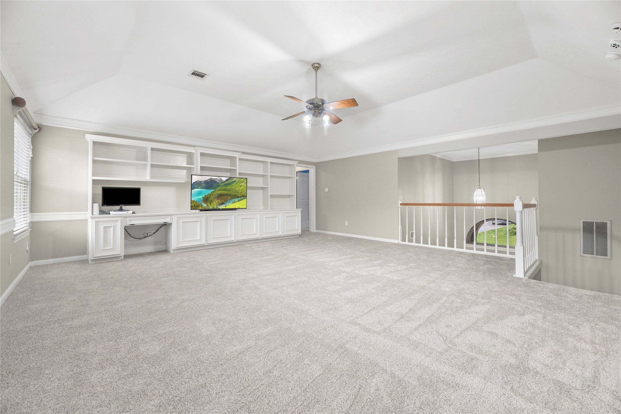 It is all fun and games upstairs in this super-sized game room, where neutral paint, updated carpet installed in July 2026, updated windows and a raised ceiling create a bright, comfortable space for everyone to relax or play.