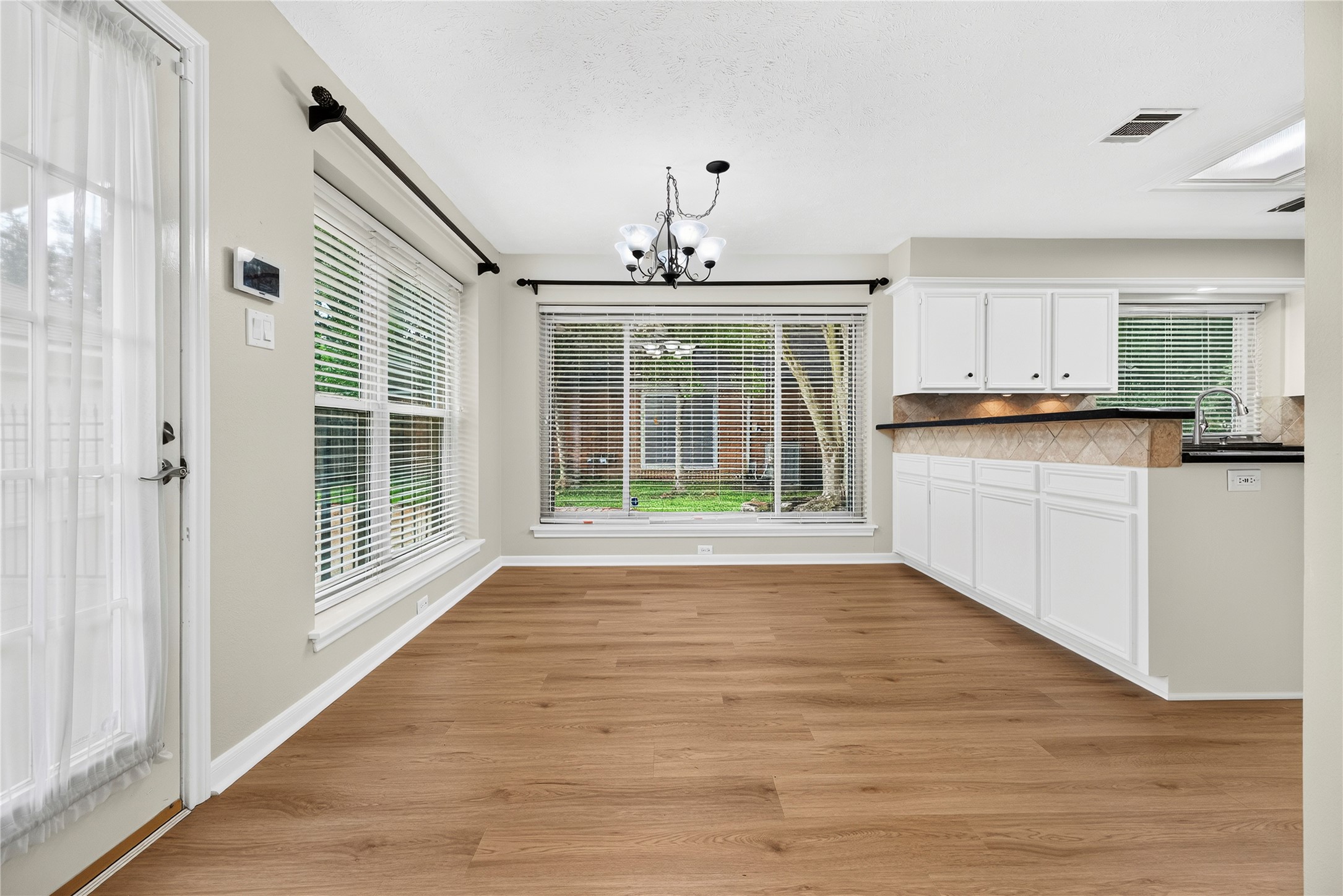 Bathed in natural light from oversized vinyl double-pane windows installed in Oct 2020, the breakfast area has a bright, cheerful feel that makes everything from busy mornings to slow weekend brunches more enjoyable. Custom window coverings add a polished finishing touch.