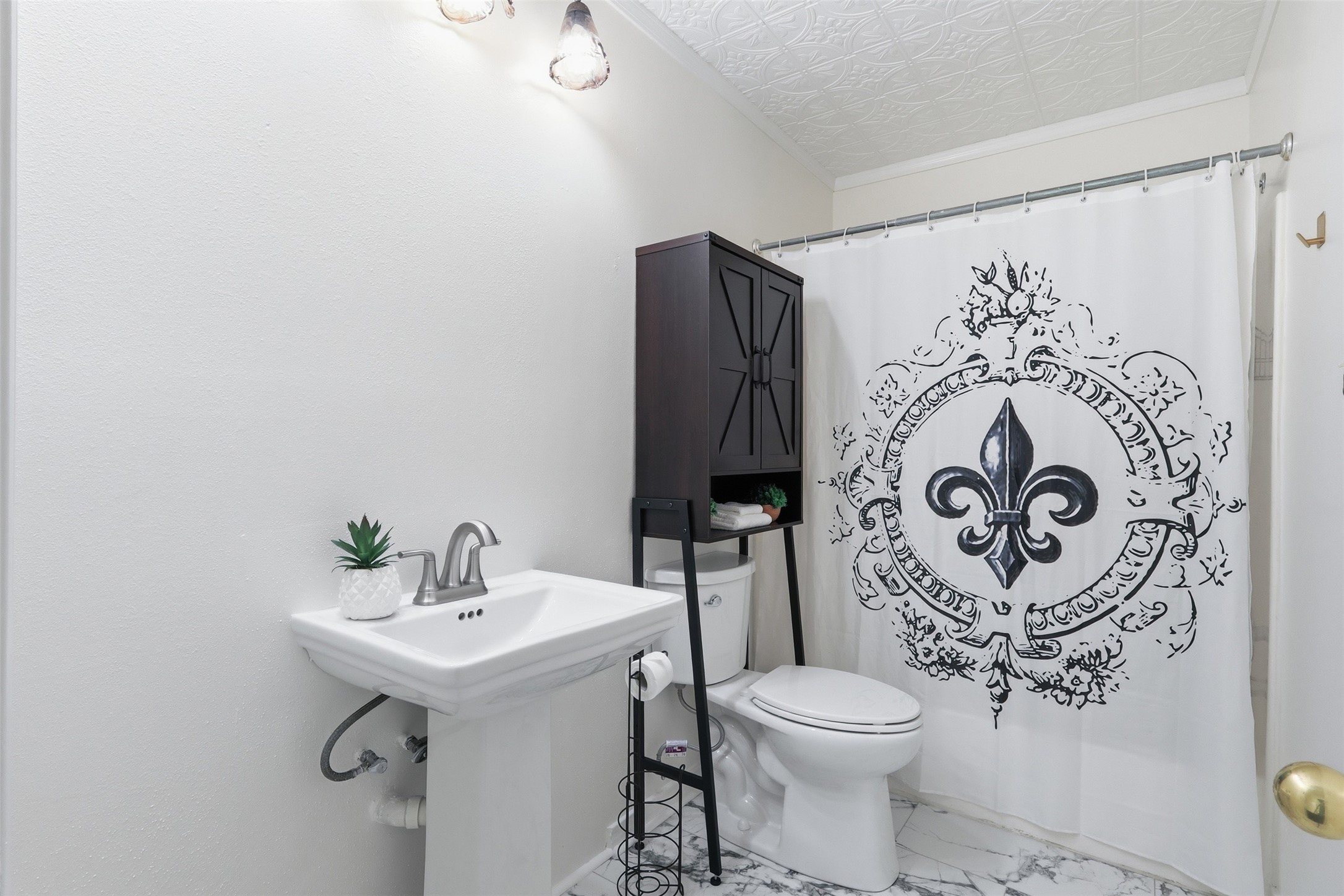 Upstairs secondary bathroom with beautiful flooring and molded ceilings.