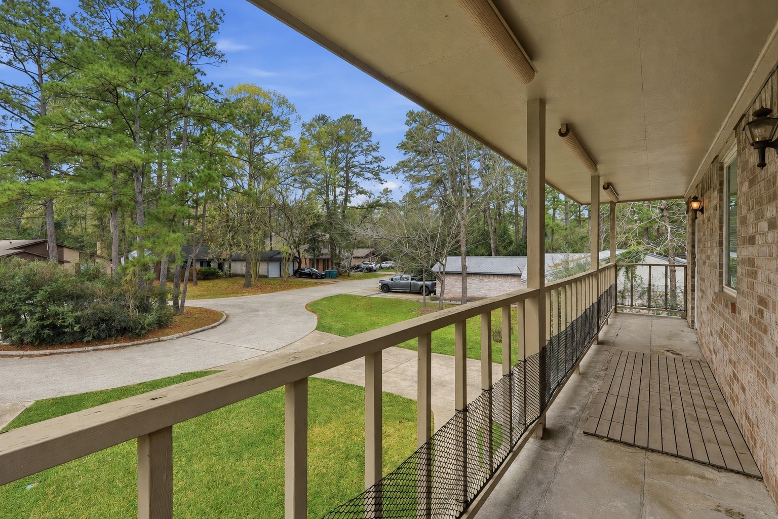 Covered second-story porch shared by the primary suite and secondary bedroom, offering a unique outdoor space with cul-de-sac views.