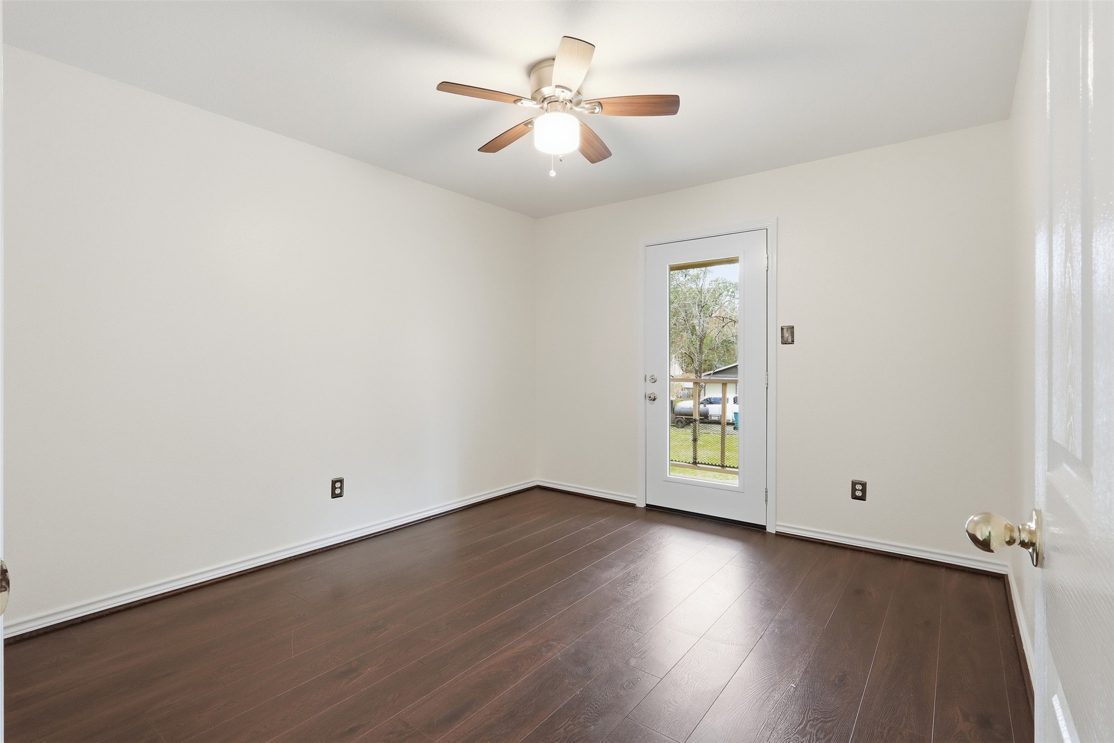 Secondary bedroom with connected balcony access and view of the charming neighborhood street.