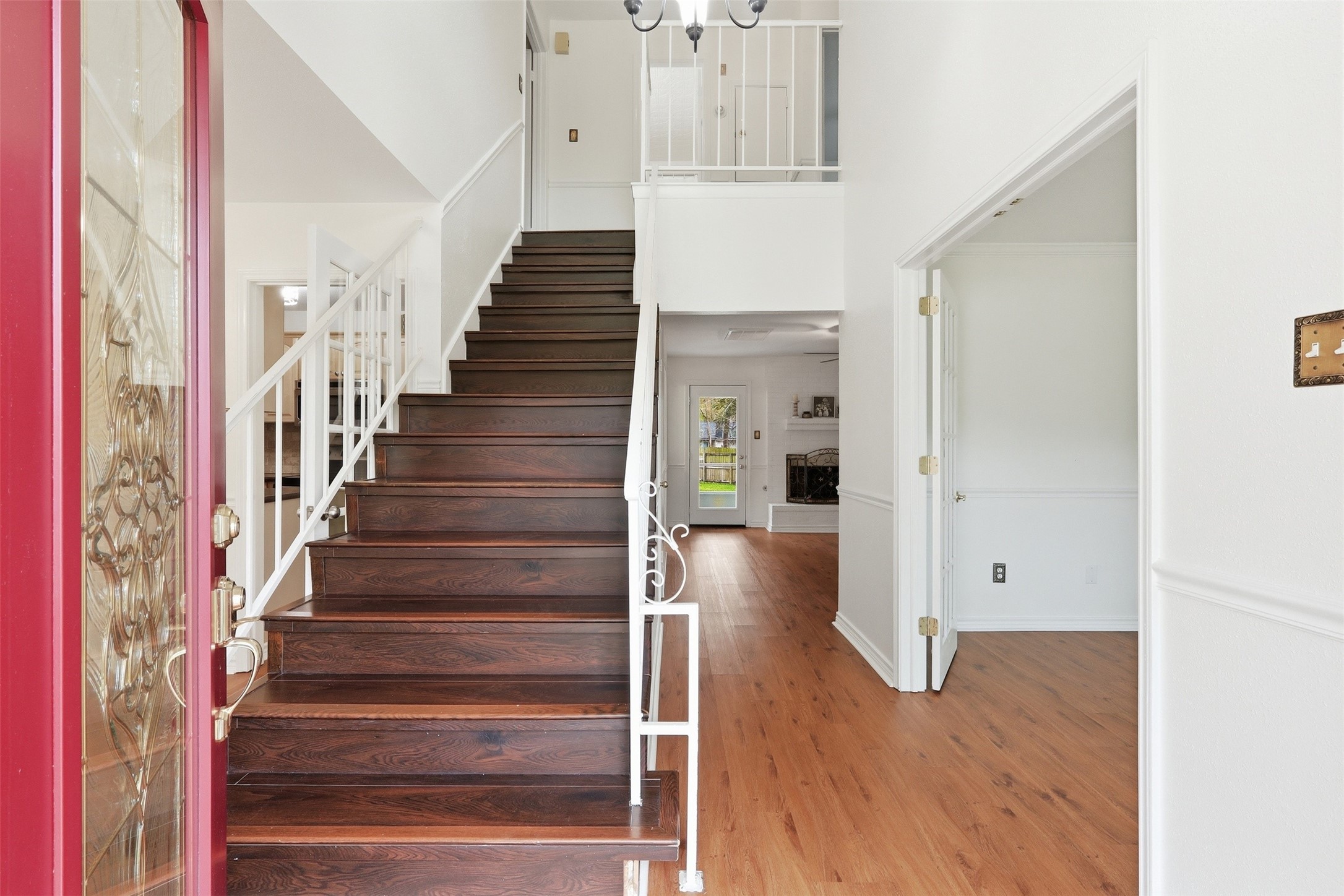This inviting entryway features a stylish staircase and opens into a bright living room.
