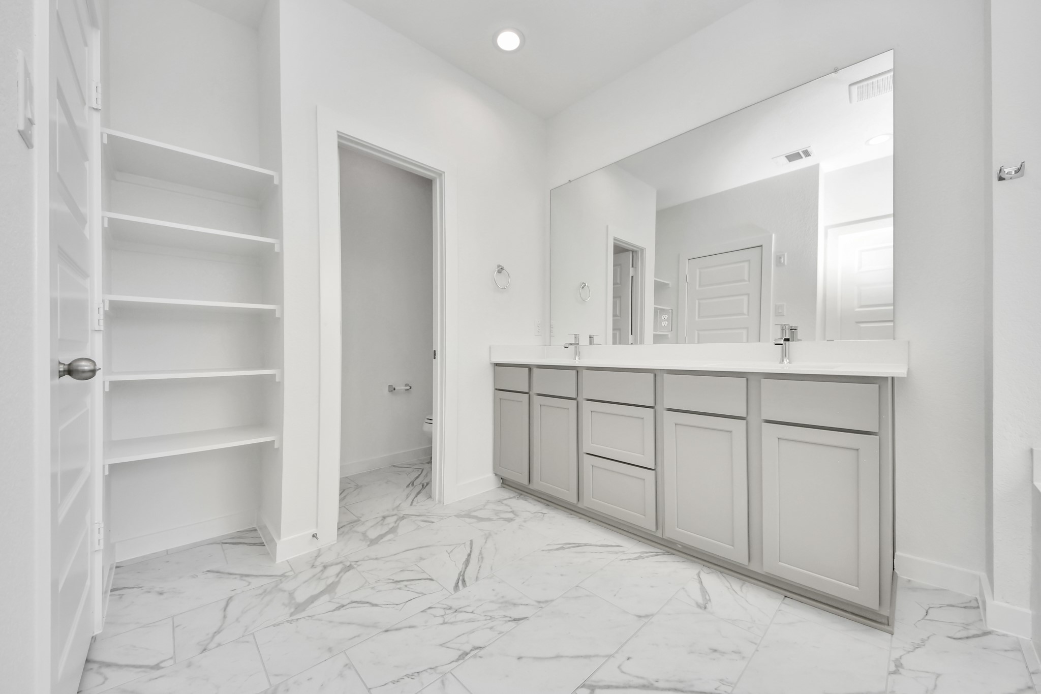 Elevate your daily routine at the elegant vanity, now equipped with double sinks, light countertops, modern hardware, and beautiful recessed lights. Sample photo of completed home with similar floor plan. Actual colors and selections may vary.