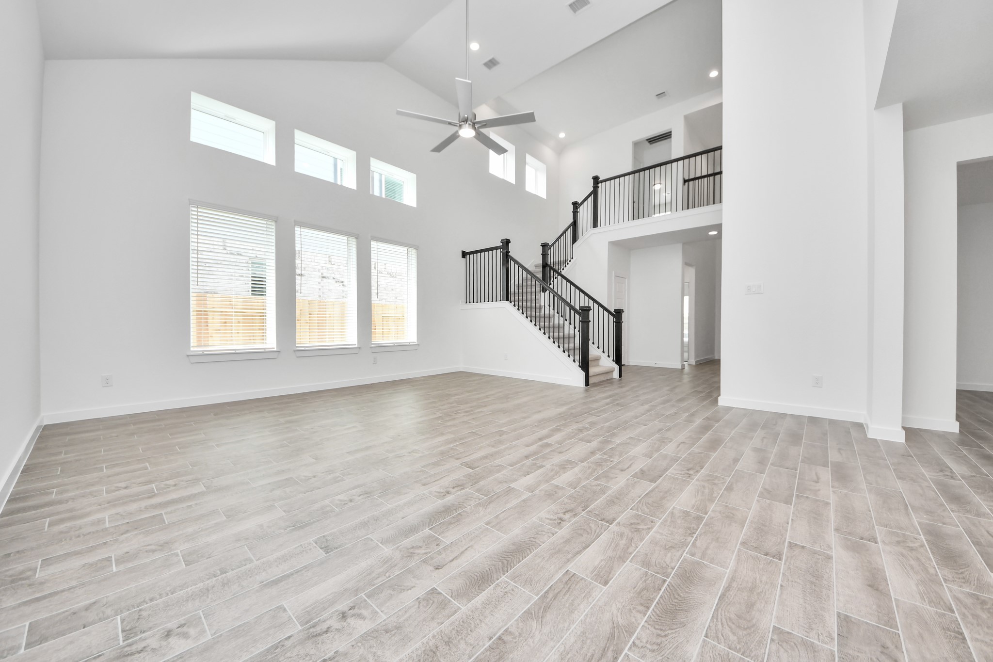 Family room flooded with natural light through the expansive windows.  The premium tile flooring adds a touch of luxury to the space, creating the perfect setting for relaxing moments and cherished gatherings with loved ones. Sample photo of completed home with similar floor plan. Actual colors and selections may vary.