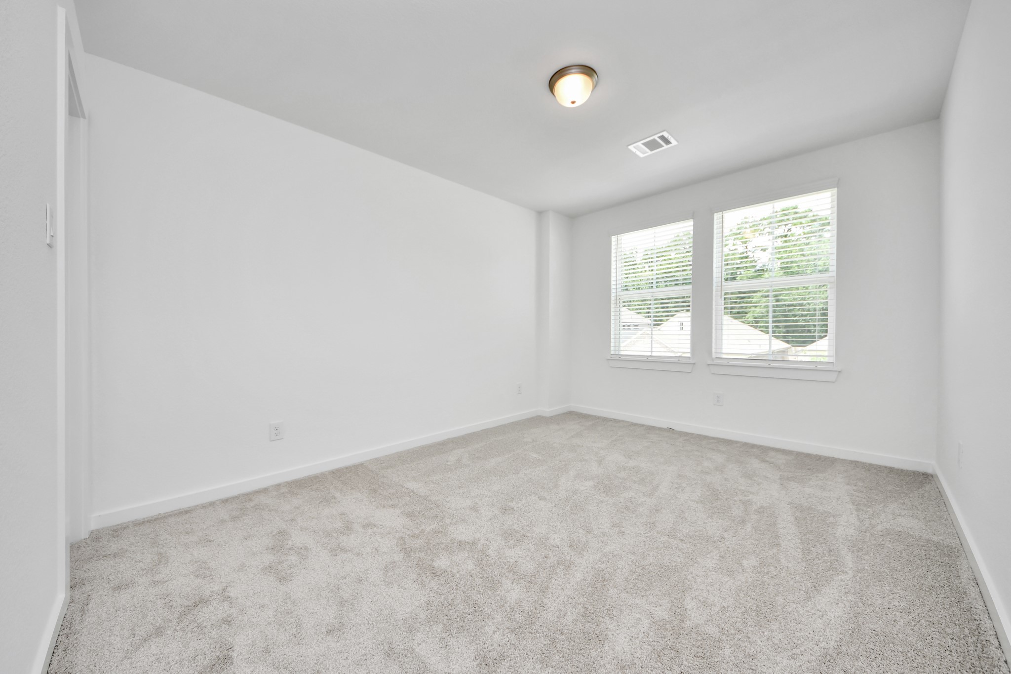Generously sized secondary bedrooms featuring spacious closets, soft and inviting carpeting underfoot, large windows allowing plenty of natural light, and the added touch of privacy blinds for your personal retreat. Sample photo of completed home with similar floor plan. Actual colors and selections may vary.