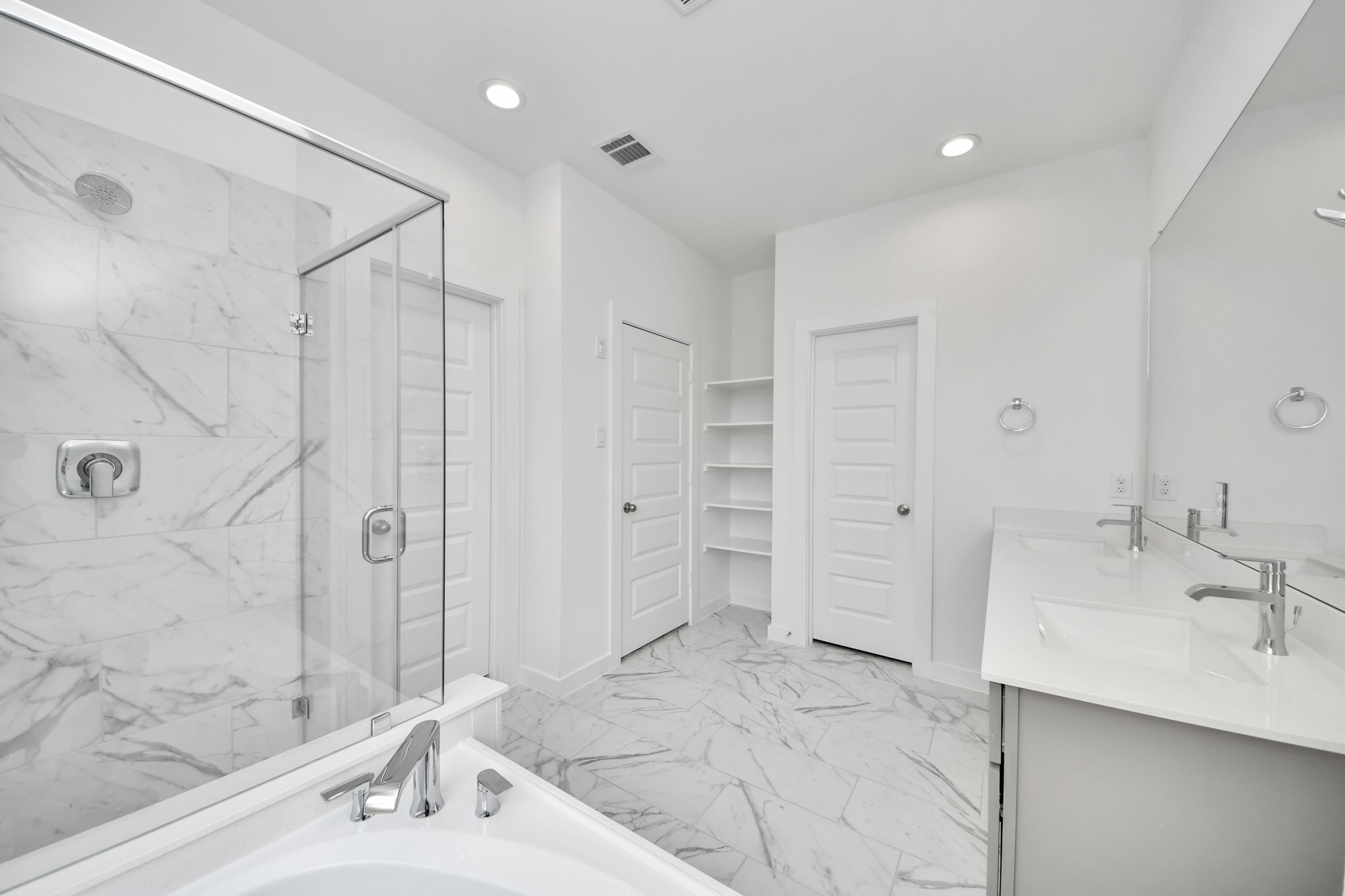Indulge in a spa-like retreat within the confines of this primary bathroom. Delight in a spacious walk-in shower enveloped in stylish tile surround, unwind in a separate garden tub adorned with custom detailing. Sample photo of completed home with similar floor plan. Actual colors and selections may vary.
