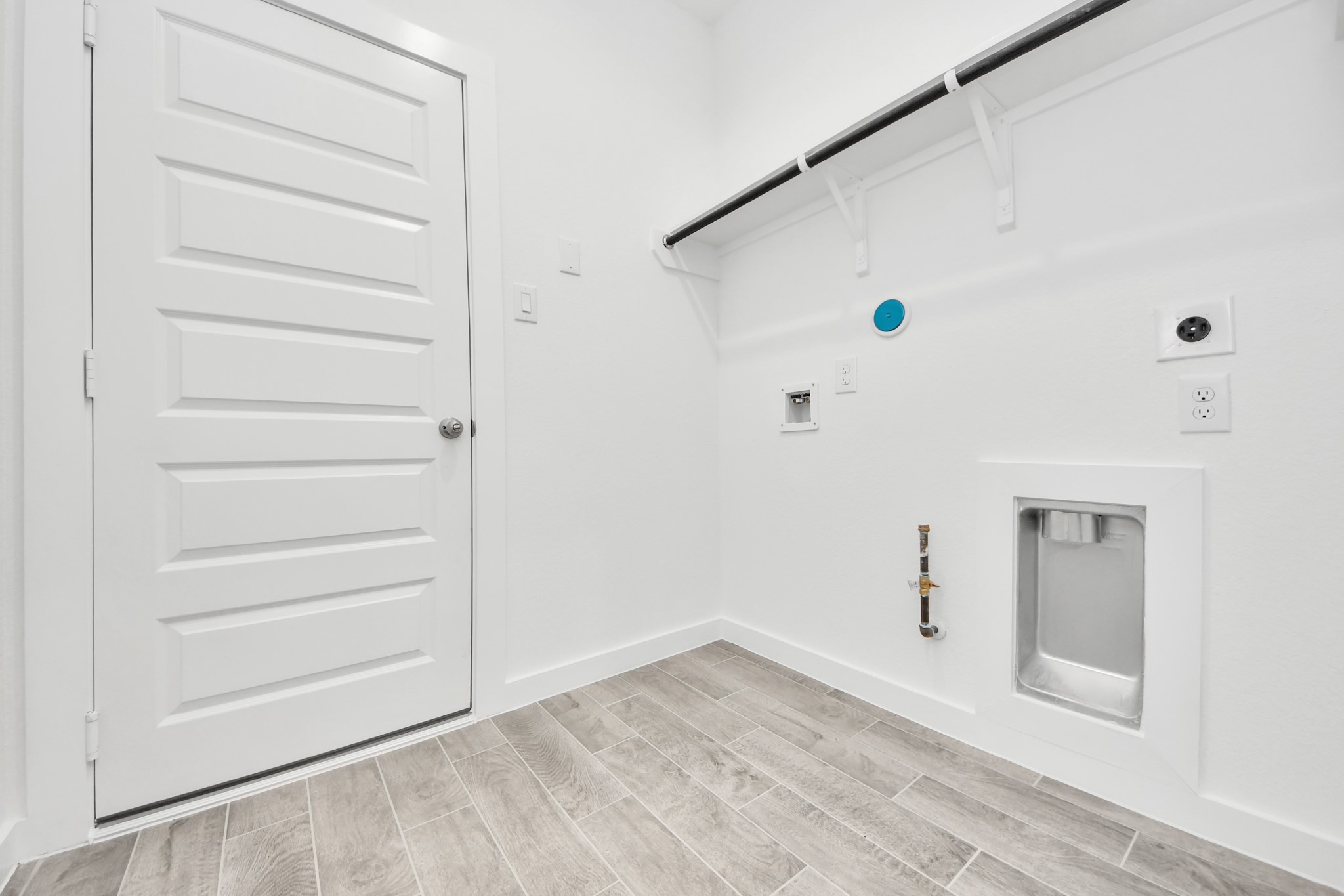 A perfect blend of functionality and comfort. Capture the essence of easy living with a first-floor laundry room, thoughtfully equipped with shelving for effortless organization. Both electric and gas connections available. Sample photo of completed home with similar floor plan. Actual colors and selections may vary.