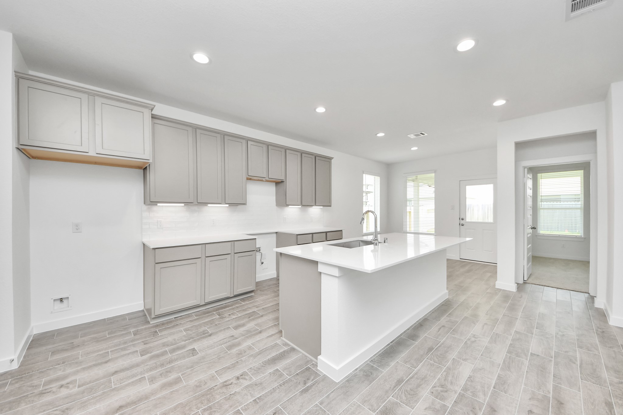 This generously spacious kitchen is a dream realized! With a massive granite island, high ceilings, soft close cabinets, granite countertops, stainless steel appliances, a sleek tile backsplash, recessed lighting, and an extended counter area, it offers both style and practicality. All this opens up to the expansive family room, creating a perfect hub for gatherings. Sample photo of completed home with similar floor plan. Actual colors and selections may vary. This generously spacious kitchen is a dream realized! With a massive granite island, high ceilings, soft close cabinets, granite countertops, stainless steel appliances, a sleek tile backsplash, recessed lighting, and an extended counter area, it offers both style and practicality. All this opens up to the expansive family room, creating a perfect hub for gatherings. Sample photo of completed home with similar floor plan. Actual colors and selections may vary.