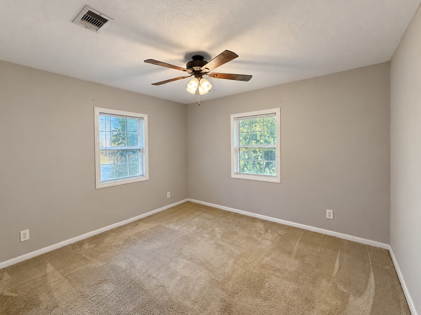 Bedroom 2 (approx. 11x12) with a ceiling fan and two windows.