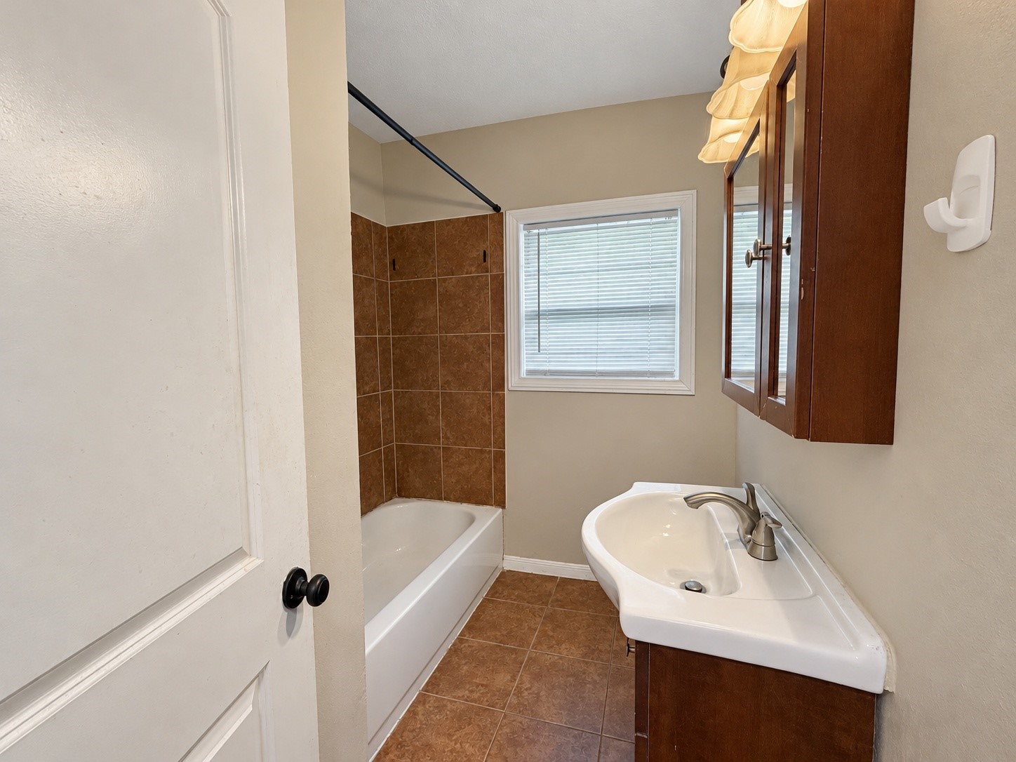 Bathroom vanity with storage and a window for natural light.