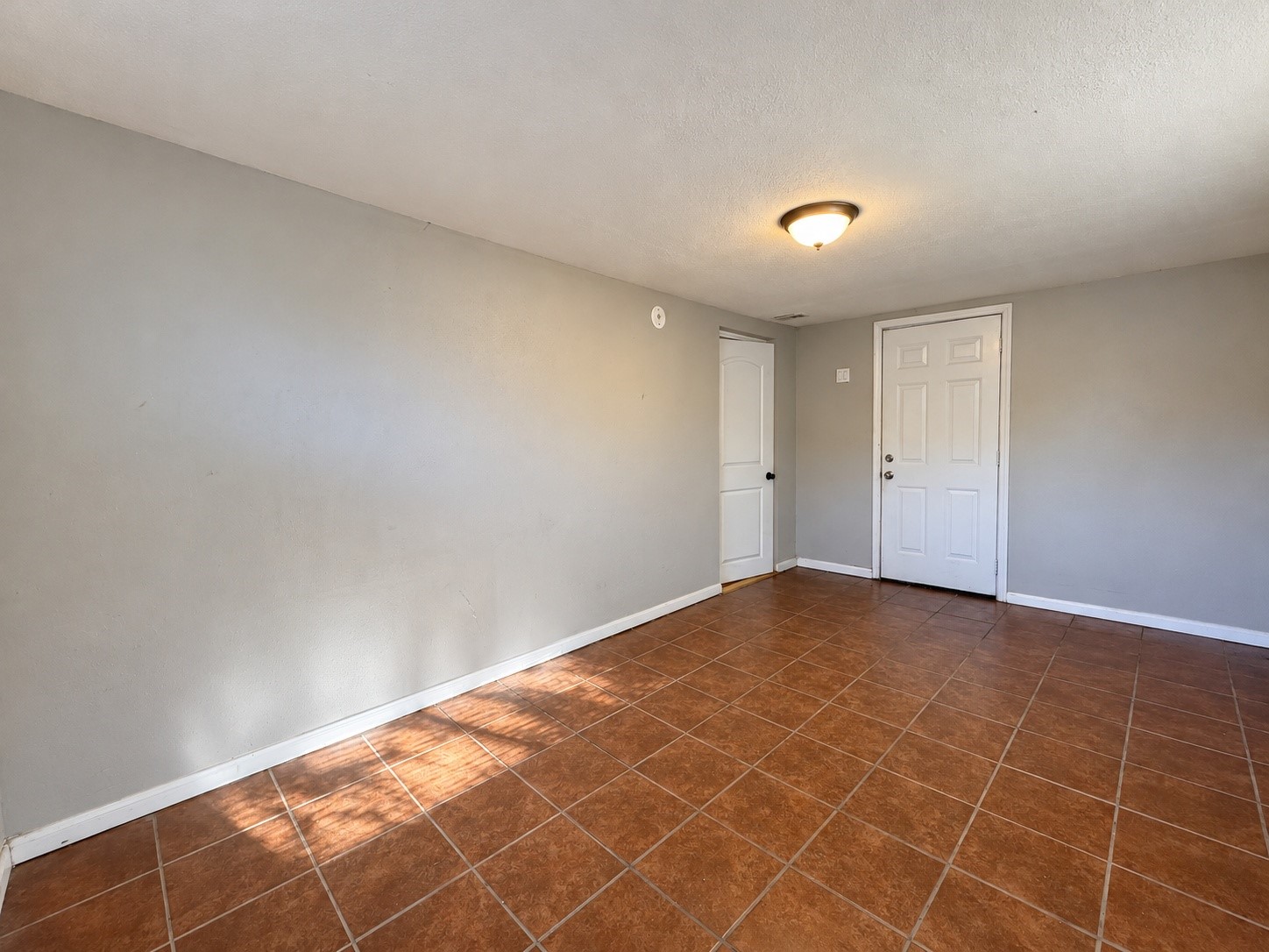 Another view of the 9.5x16 laundry and flex room, with tile floors and natural light.