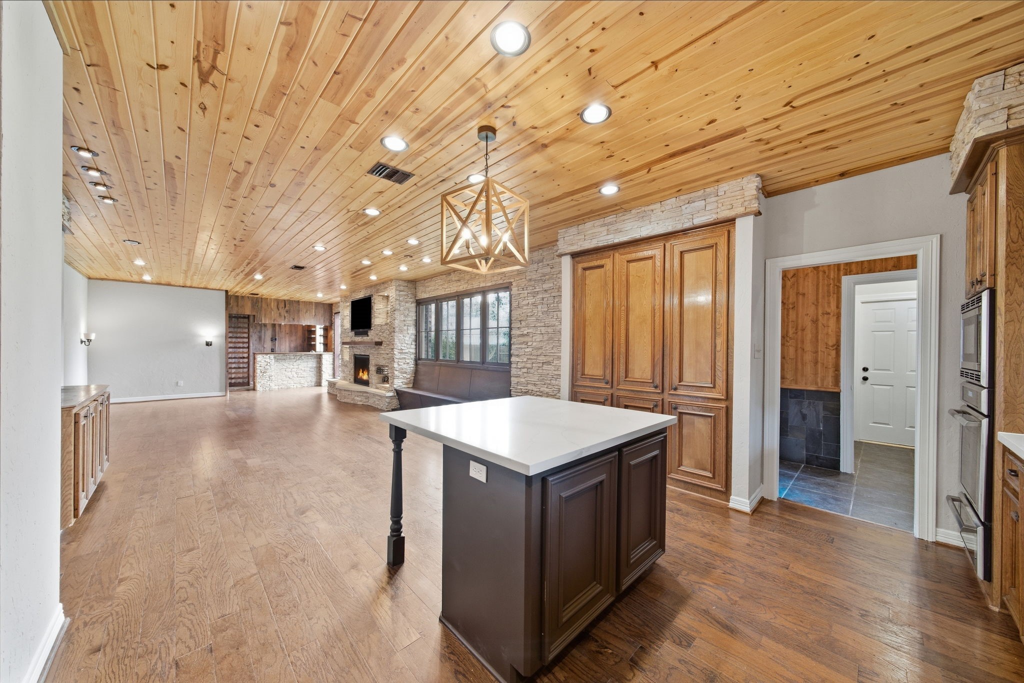 A large center island provides generous prep and gathering space while contrasting beautifully against the surrounding cabinetry.