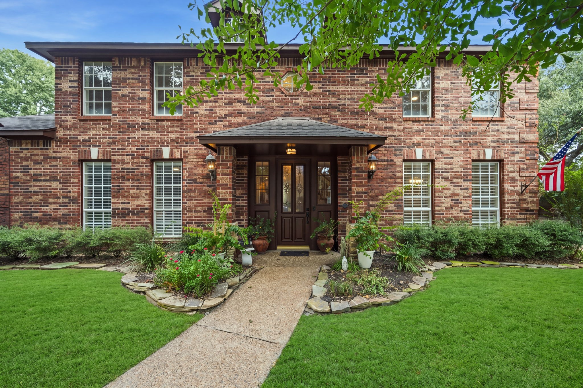 Charming two-story brick home with a welcoming front entrance, flanked by manicured landscaping and large windows that brighten the interior. Charming two-story brick home with a welcoming front entrance, flanked by manicured landscaping and large windows that brighten the interior.