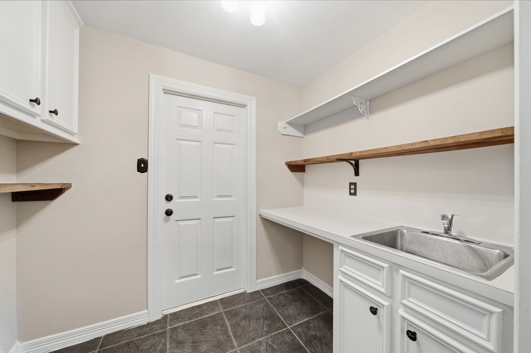 Conveniently positioned along the back hall near the three-car garage, the laundry room offers an easy drop zone for busy everyday routines.