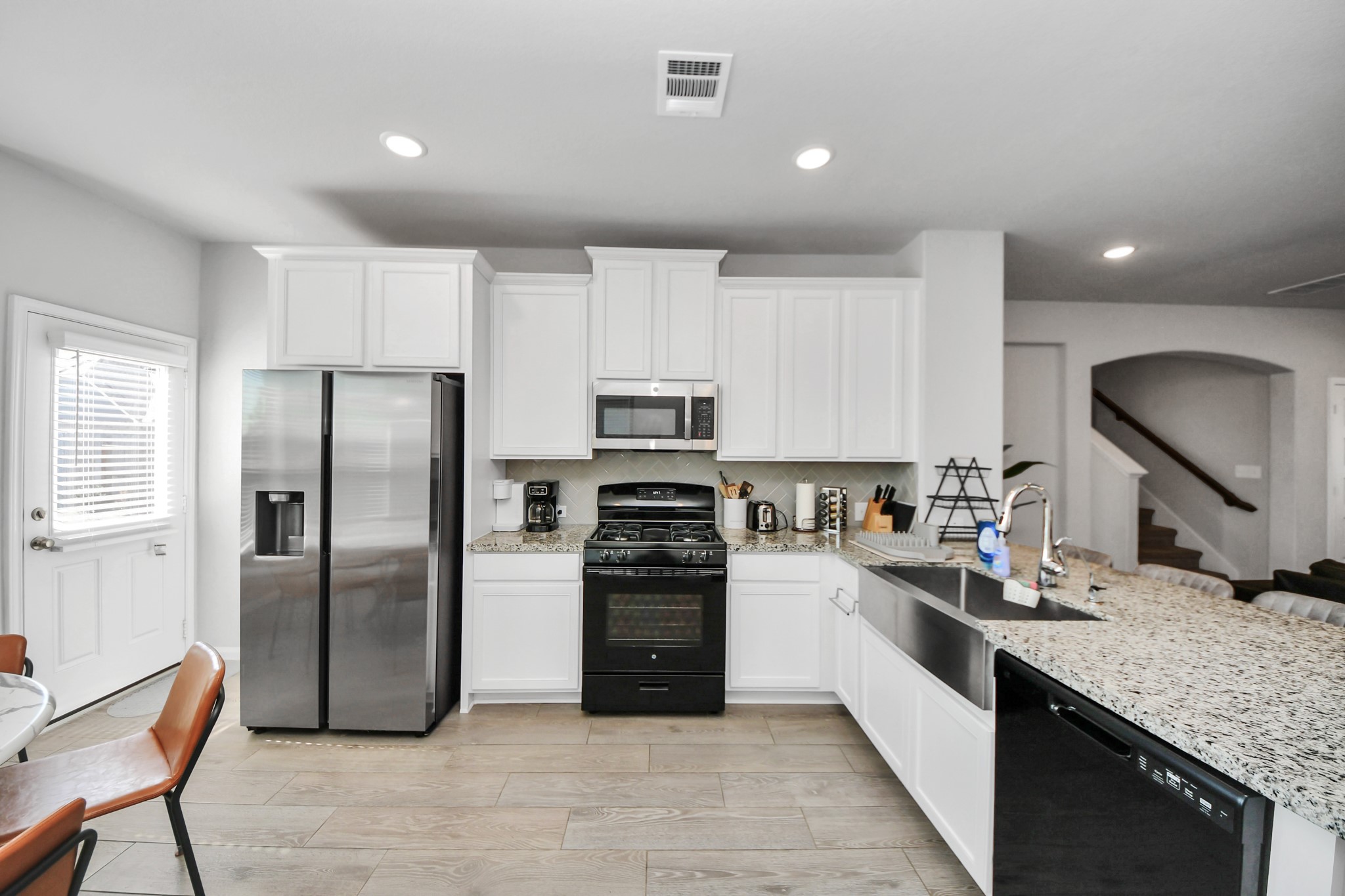 White kitchen with large farmhouse style sink.