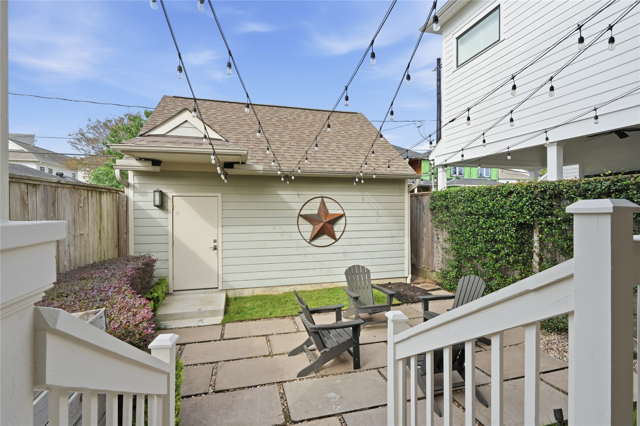 Enjoy outdoor living on the charming patio, complete with caf lighting, gathering space, and direct access to the detached two-car garage.