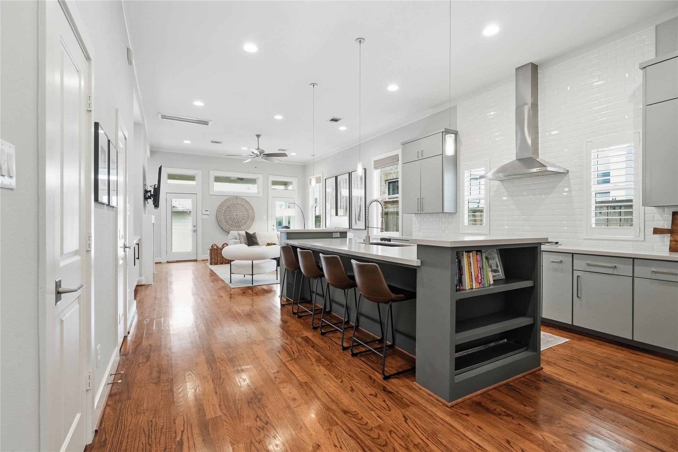 Chefs kitchen features an oversized island with bar seating, abundant cabinetry, stainless steel appliances, and a spacious walk-in pantry, all seamlessly connected to the home's open-concept living and dining areas.