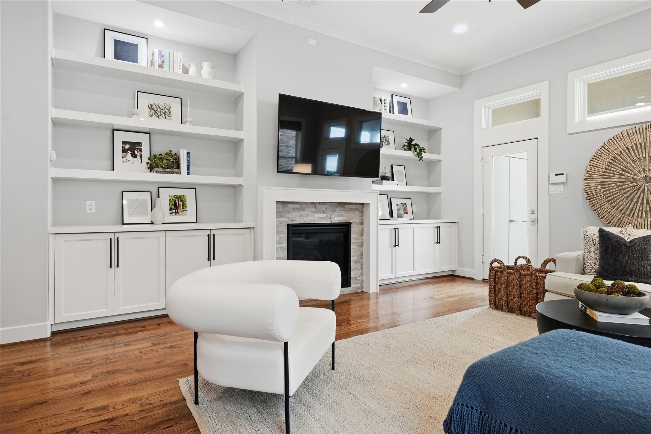 The light-filled living room showcases a gas fireplace framed by custom built-ins, creating an inviting space for relaxation and gathering.
