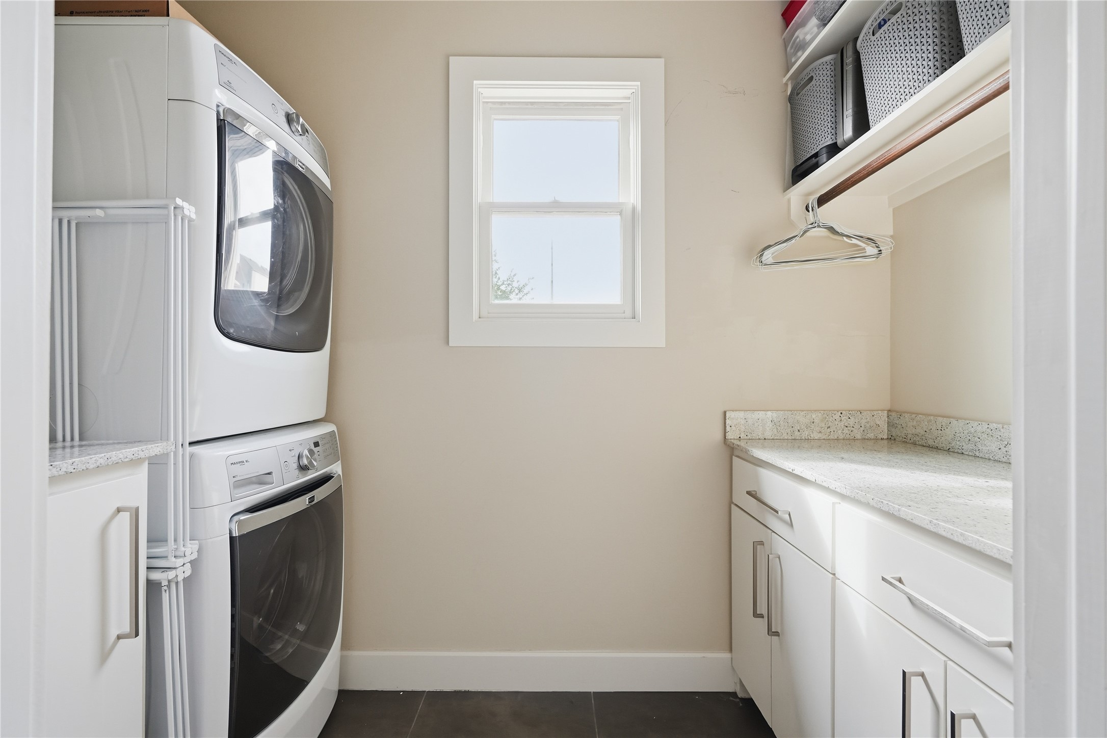 Upstairs laundry room offers ample storage, workspace for folding, and convenient access to the home's bedrooms.