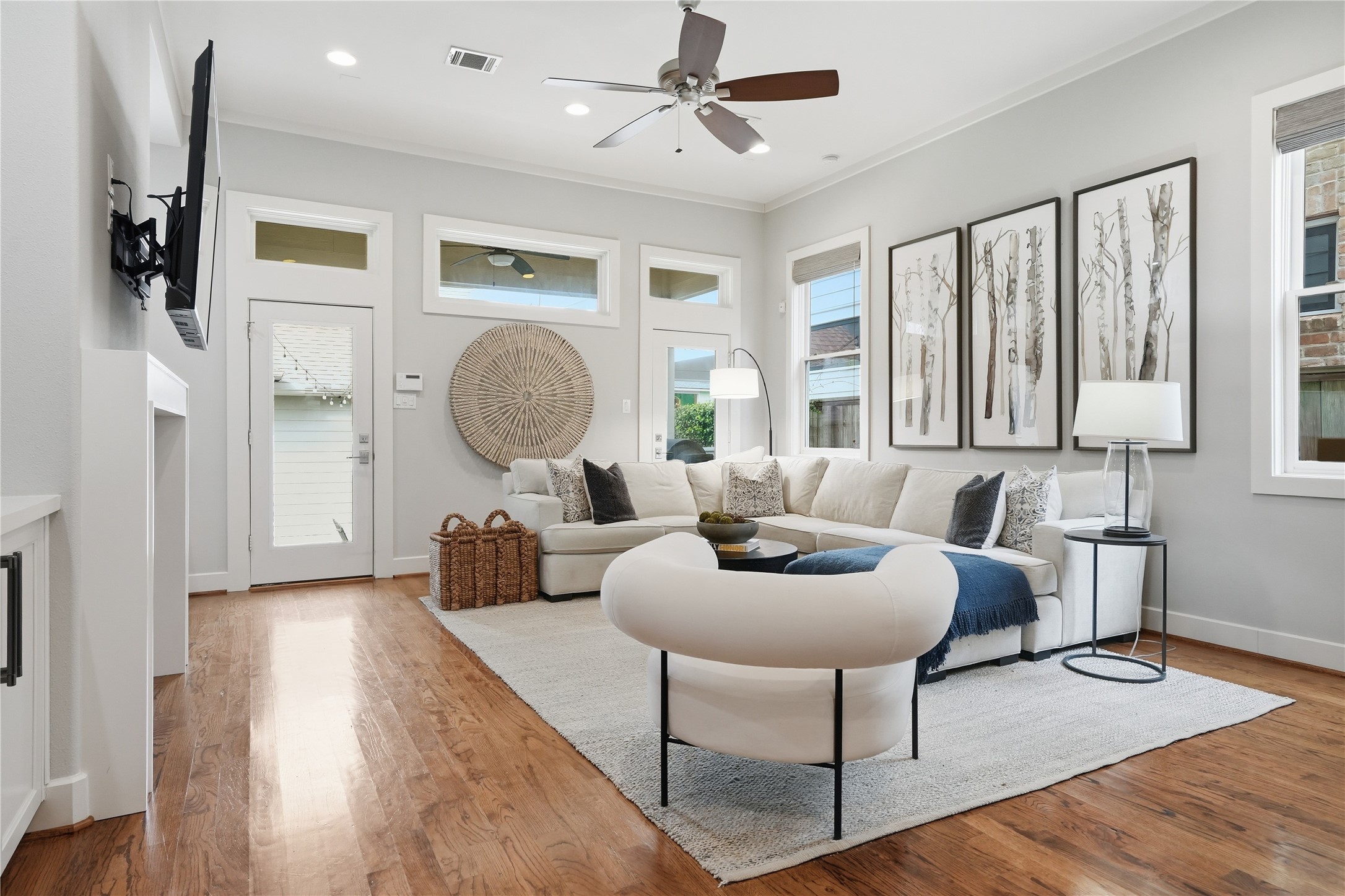 Expansive windows and a door leading to the backyard flood the living room with natural light and provide effortless access to outdoor living space.