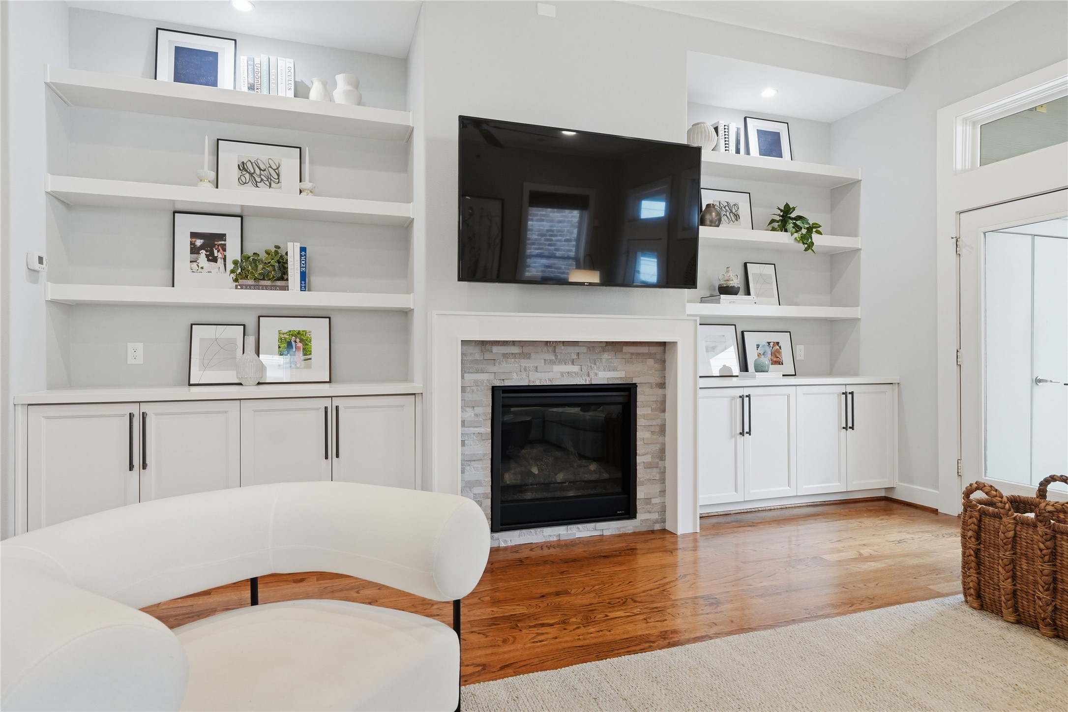 The light-filled living room showcases a gas fireplace framed by custom built-ins, creating an inviting space for relaxation and gathering.