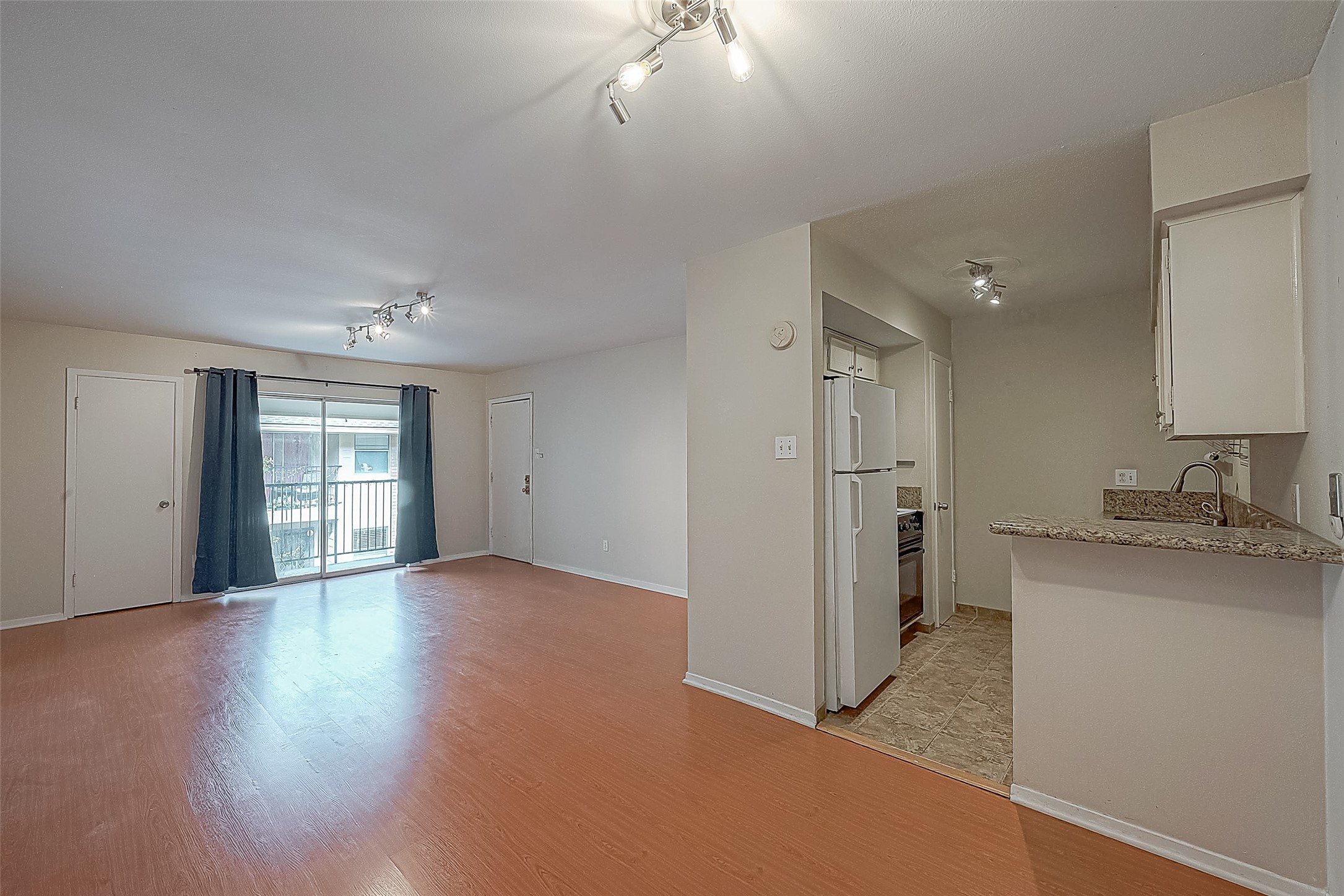 The dining area flows seamlessly between the kitchen & living room, creating an open and connected feel. The breakfast bar provides additional seating and makes it easy to enjoy a quick meal or visit while cooking. Notice the engineered wood flooring throughout the living & dining areas.