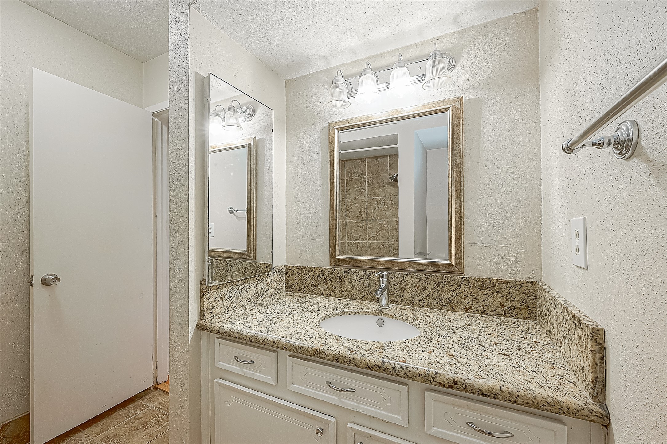 Bath measures 7.11 x 6.9 and features a granite-topped vanity with updated faucet, framed mirror & updated lighting. Just outside the bath is a hallway linen closetanother convenient spot for towels, linens & everyday essentials.