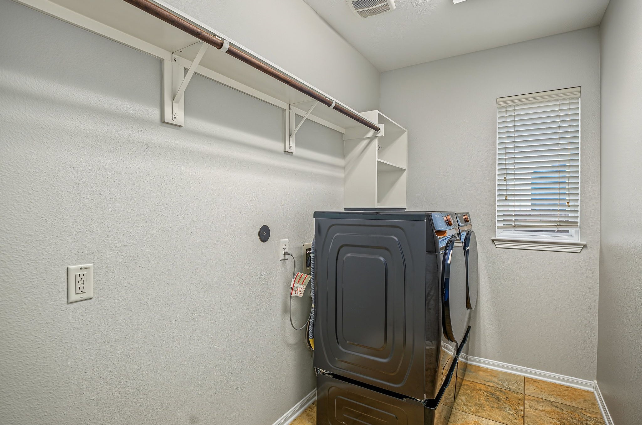 Laundry room just off the kitchen! Room for a fridge here too! Long bar for those 'hang dry' garments or just out the dryer clothes that need to be hung.