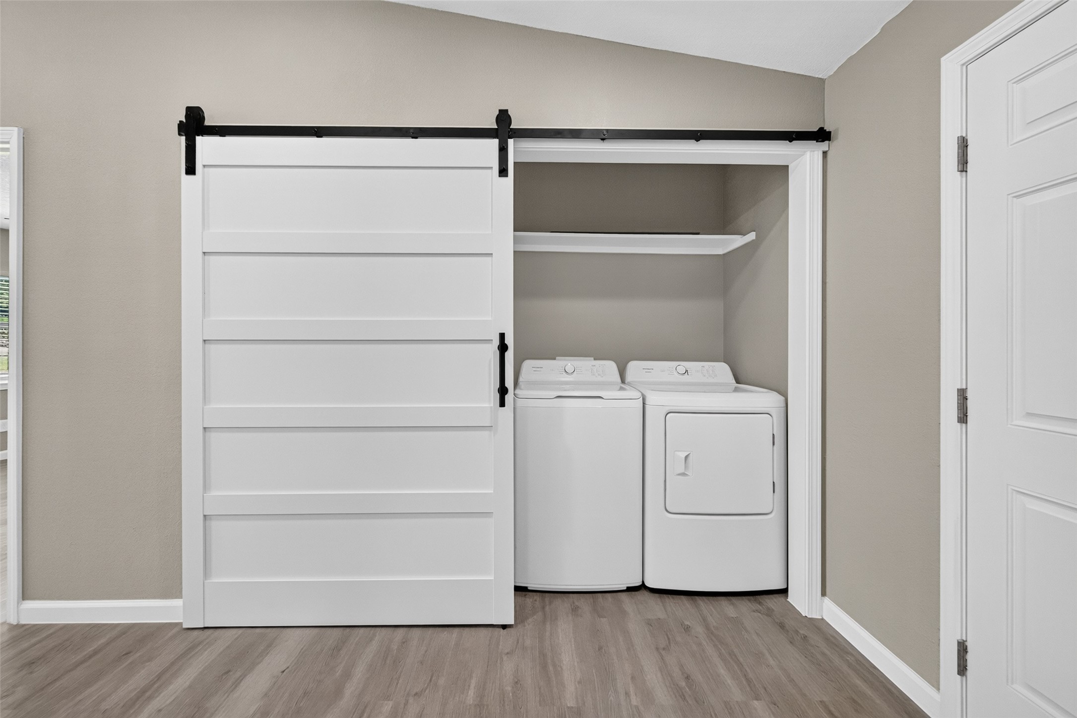 Utility area with sliding barn door (washer and dryer included)