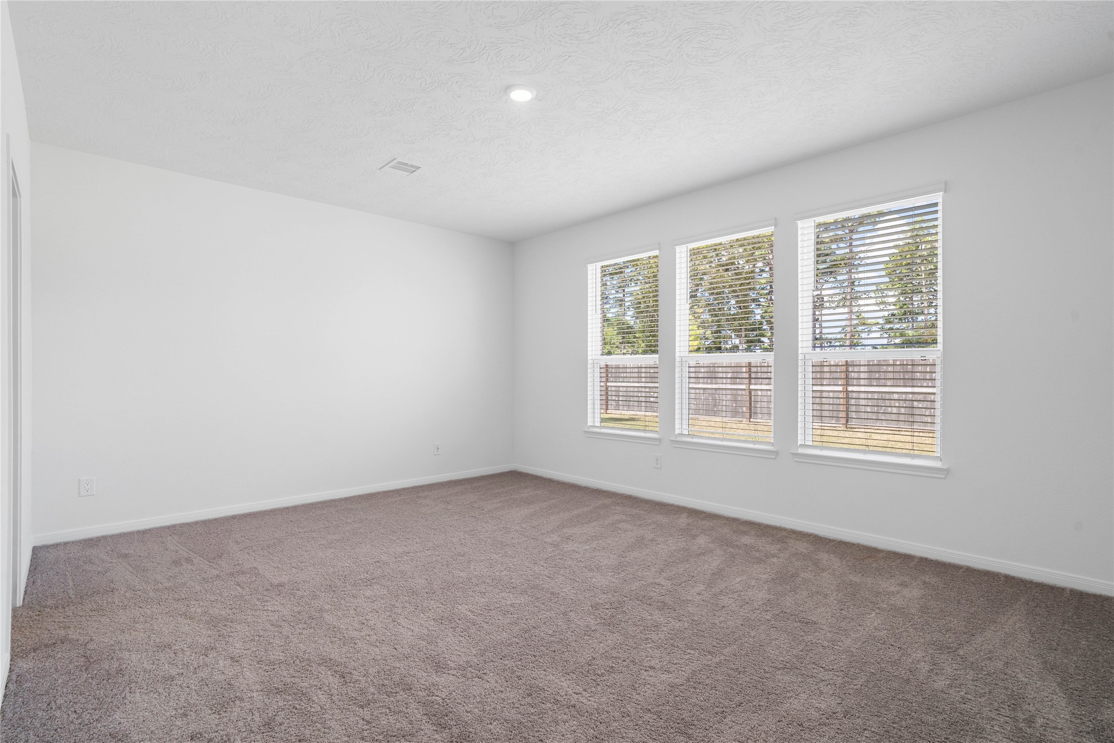 Relax and recharge in this stunning primary suite! Enjoy the comfort of plush carpeting, neutral-toned walls, high ceilings, recessed lighting, and large windows with privacy blinds that fill the room with natural light.