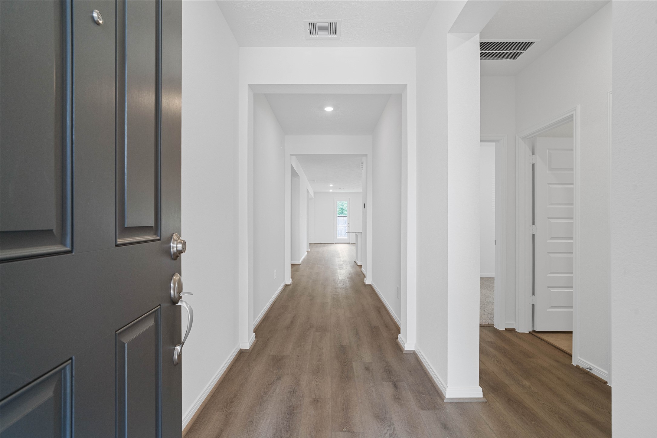 Step into a bright and welcoming foyer that sets a sophisticated tone for the rest of the home. This inviting entrance features Layton Lake Toasted Taupe Vinyl Plank flooring that seamlessly guides you into the main living areas.