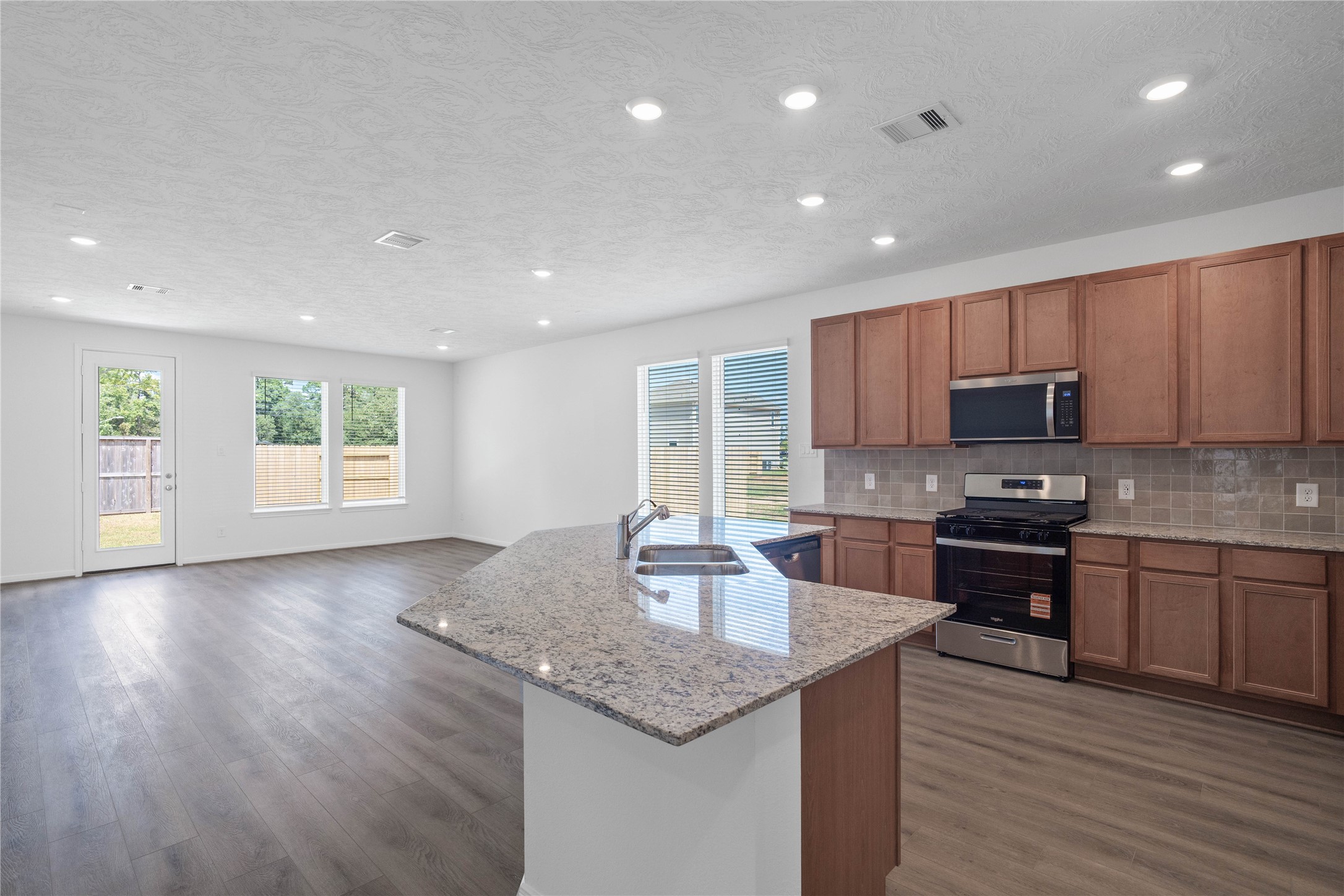 Spacious open-concept living, dining, and kitchen area featuring abundant natural light and seamless flow.