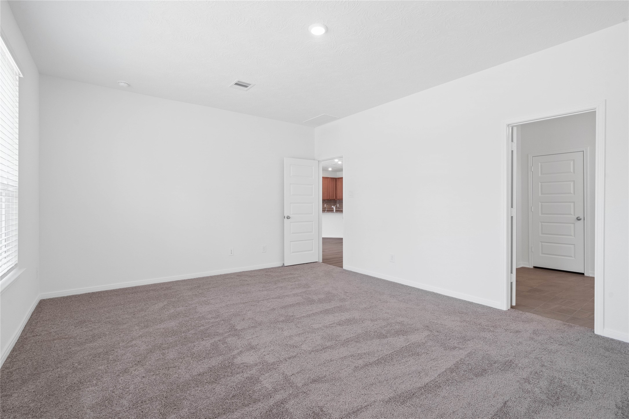 Additional view of the primary bedroom looking towards the primary bathroom.