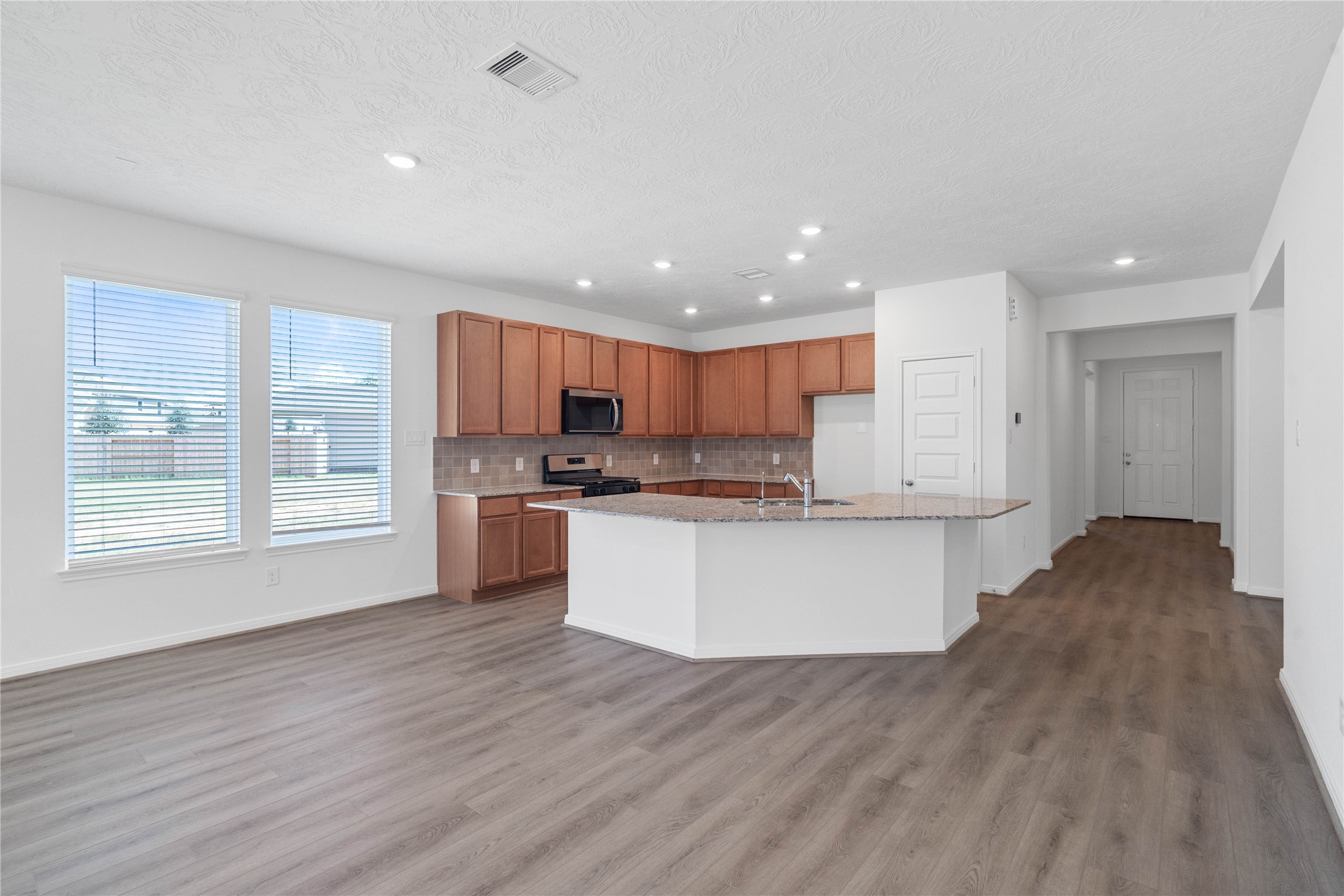 Create lasting memories around the table with family and friends in this inviting dining space! It showcases high ceilings, large windows with privacy blinds, vinyl plank flooring, and recessed lighting for a warm and welcoming atmosphere.